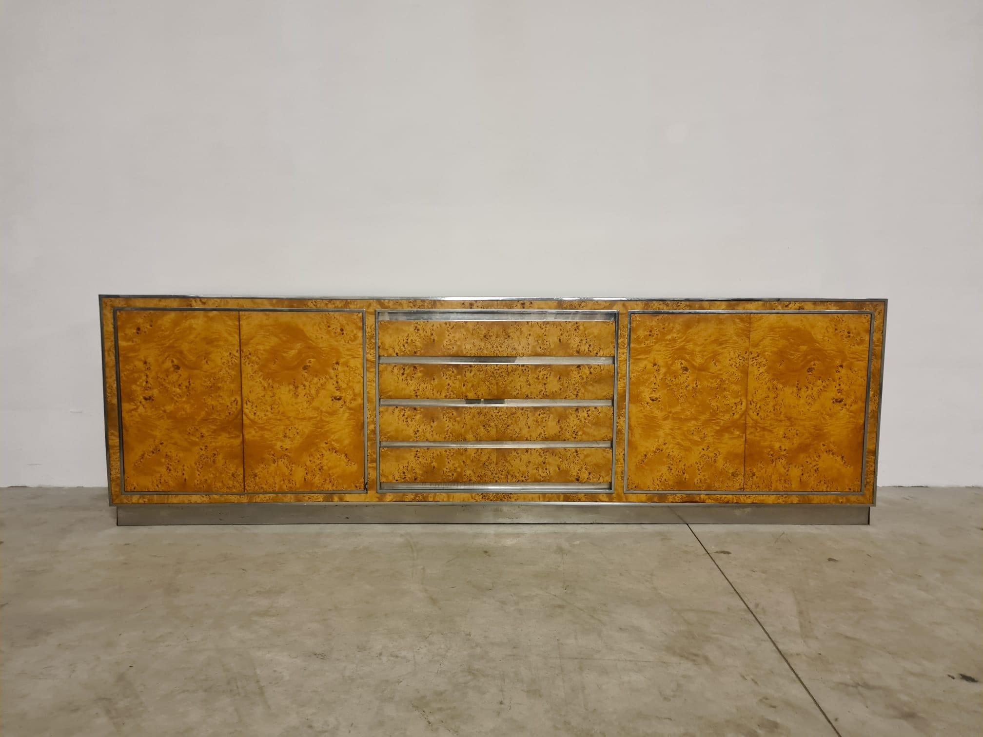 Credenza in radica nello stile di Mario Sabot.

Elegante sideboard in radica di rovere con dettaglio in acciaio cromato.

Produzione italiana degli anni 70'.

La credenza presenta 4 grandi cassetti centrali e due vani a doppia anta