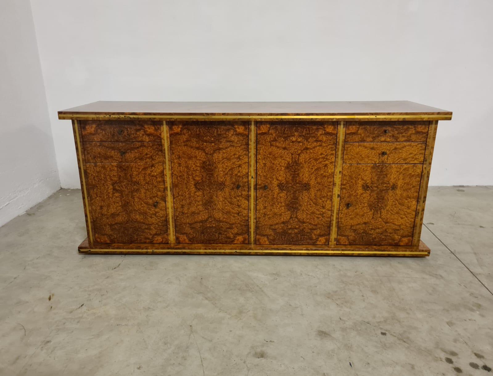 Sideboard aus Bruyèreholz und Messing.

Elegantes Sideboard aus den 1970er Jahren aus Bruyèreholz und Messingdetails.

Bestehend aus vier Schubladen und vier Türen mit Glasauflagen.

Hergestellt in Italien, aus hochwertigen und erstklassigen