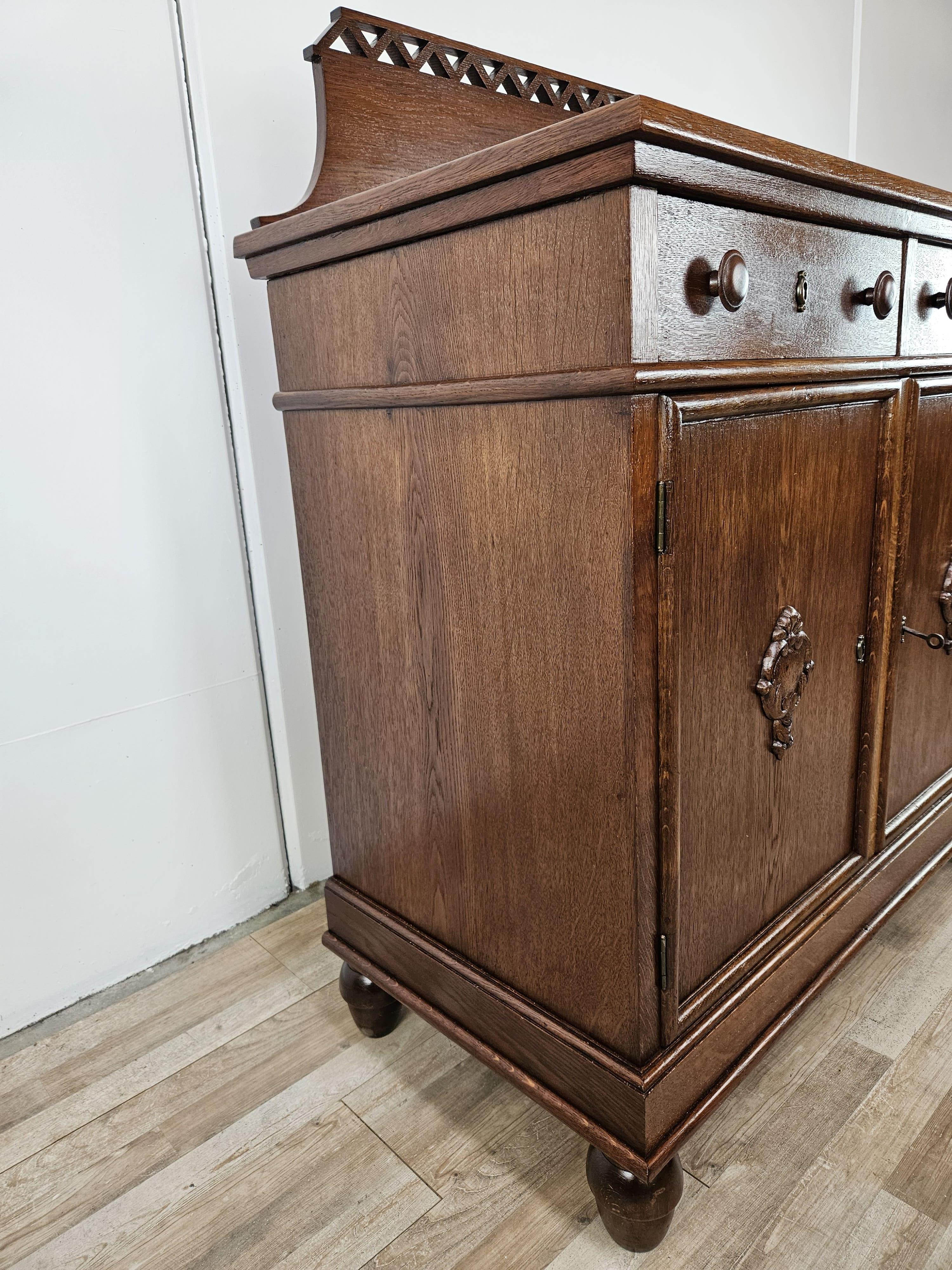 Oak hall or living room sideboard with double drawer and two doors with interior shelf.

The cabinet features an ornate and carved riser, high feet, and thanks to its small size it can be placed in smaller rooms.

The key works only for opening the