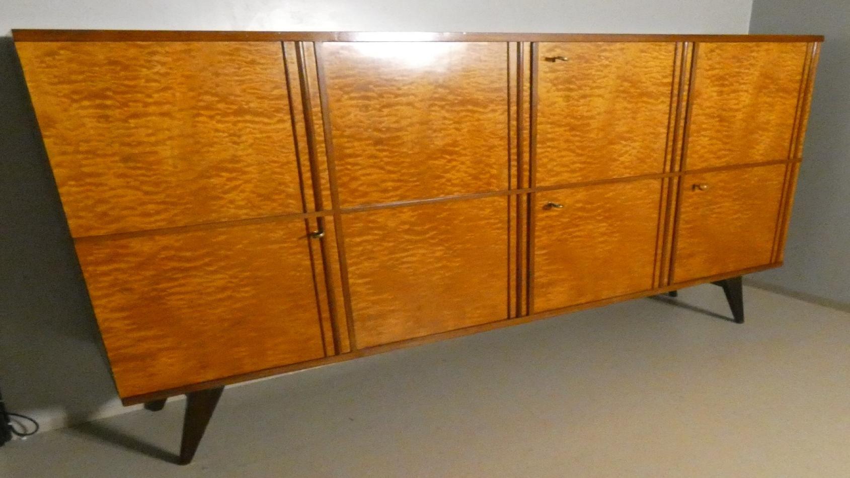 Large sideboard made of solid Teak wood, handcrafted in the 1970s in Italy. An extremely storage furniture, the sideboard also has 4 drawers with steel handles. Looking at the sideboard from the front, there is a single full-height hinged door with