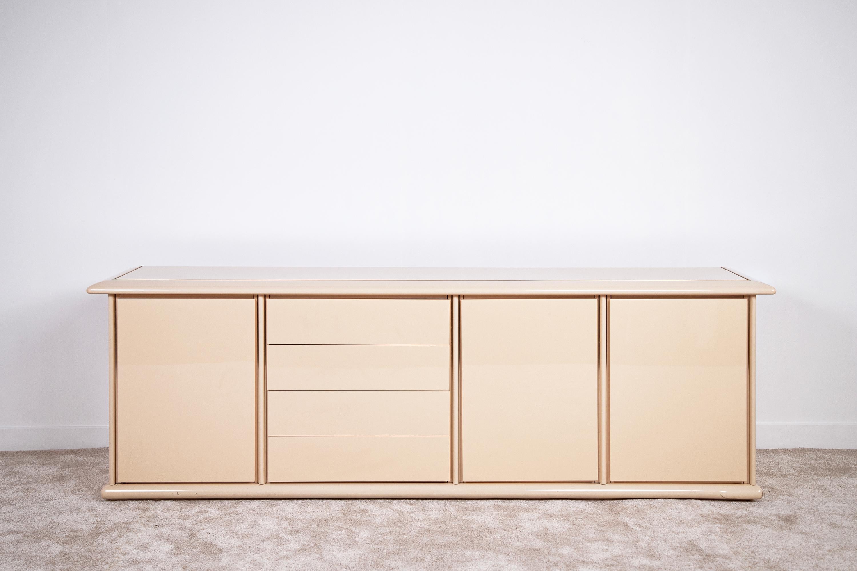 Elegant sideboard-credenza in the Maison Jansen and Jean Charles style, made of lacquered wood finished with brass details. 1980s French production in Hollywood Regency style. The contrasting ivory color with brass frames gives an uber-chic touch to
