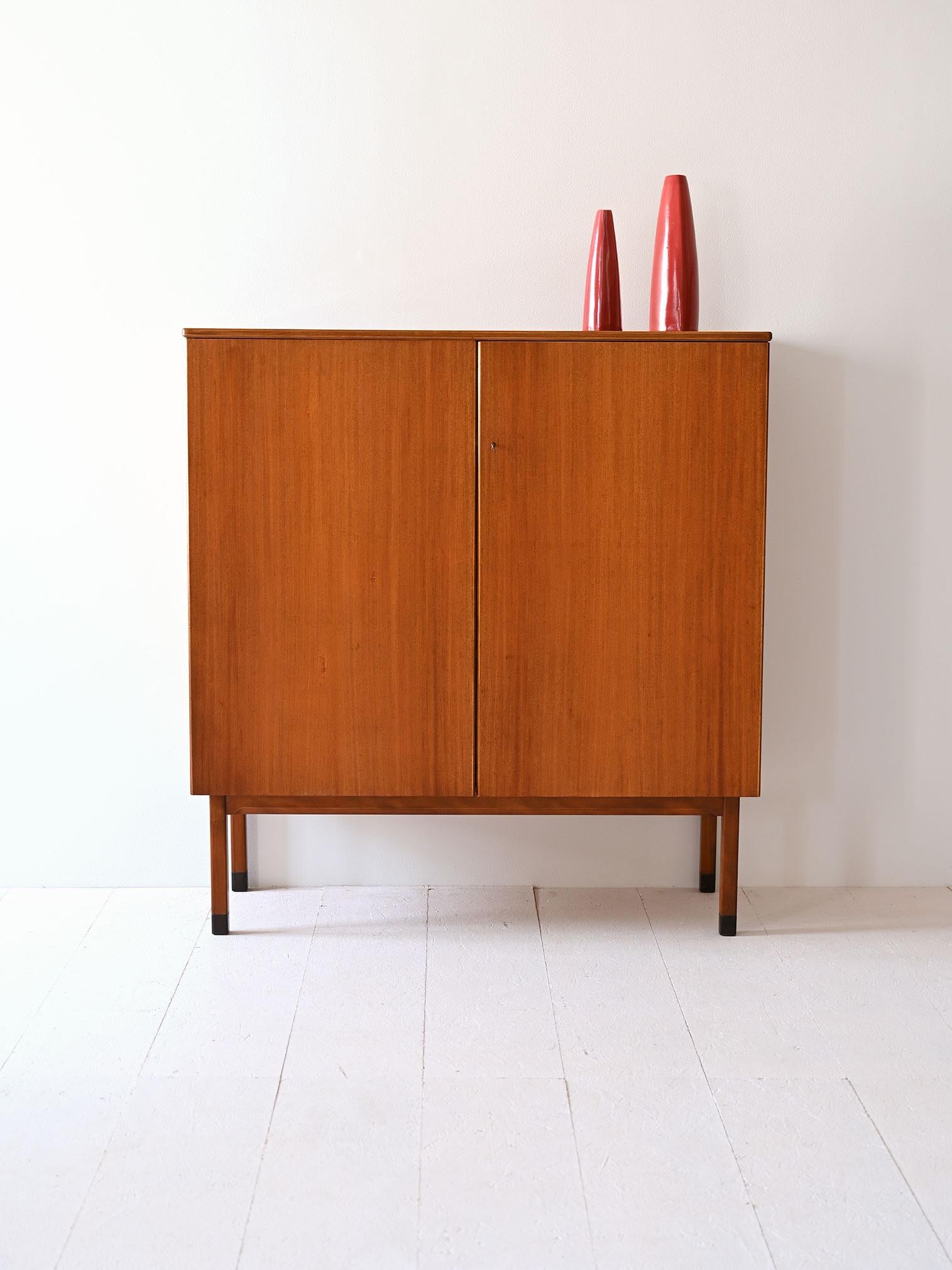 Vintage Swedish mahogany cabinet made by Bodafors that embodies the timeless elegance of Scandinavian design. The two lockable hinged doors guard a space inside divided by two shelves and two small drawers. 

Mahogany, with its warm tones and