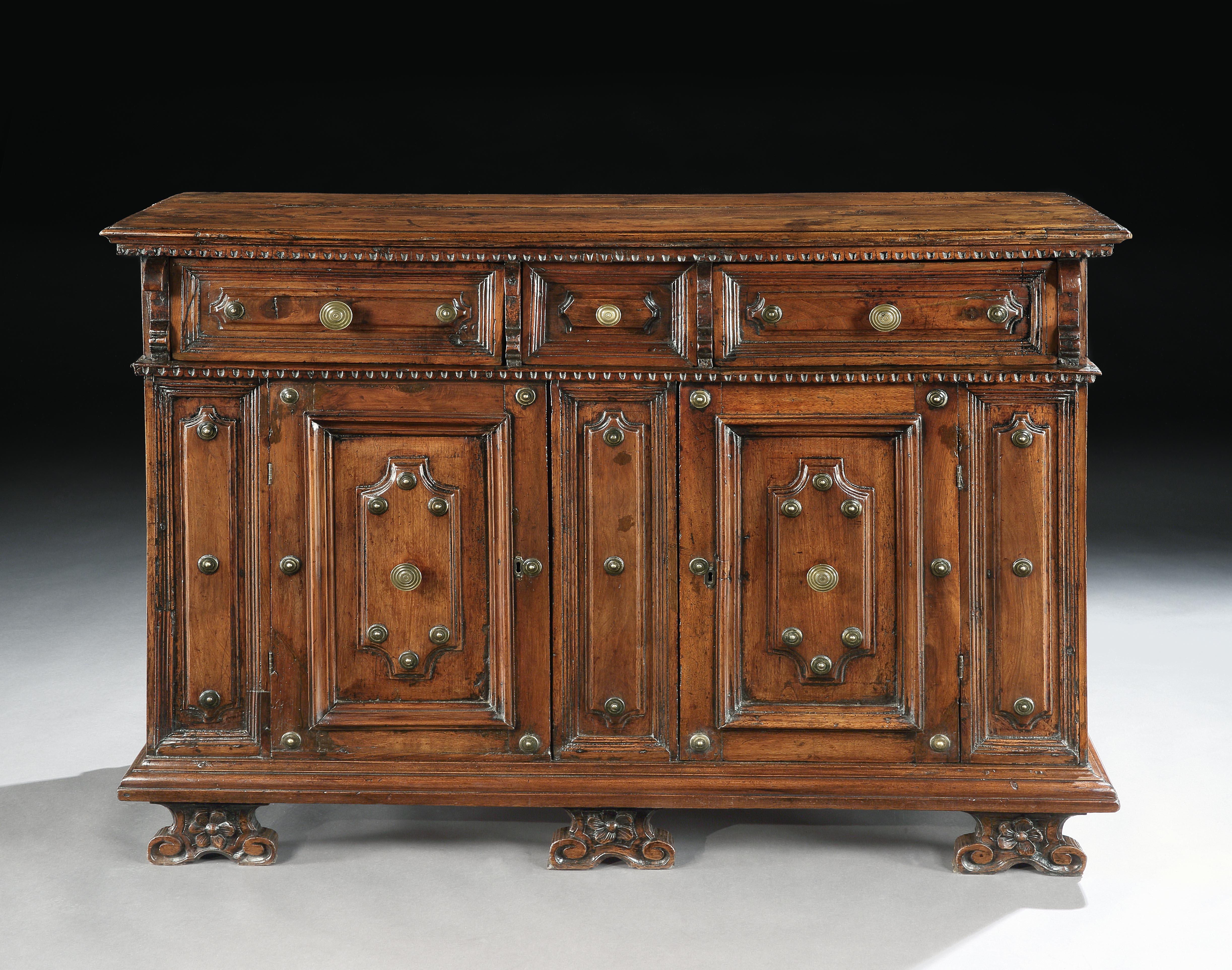 This is a fine example of a Renaissance period credenza or sideboard that would have been made for an Italian Palazzo. The shaped moulded panels and brass studwork ornamentation are typical decorative features from Bologna. This credenza is a