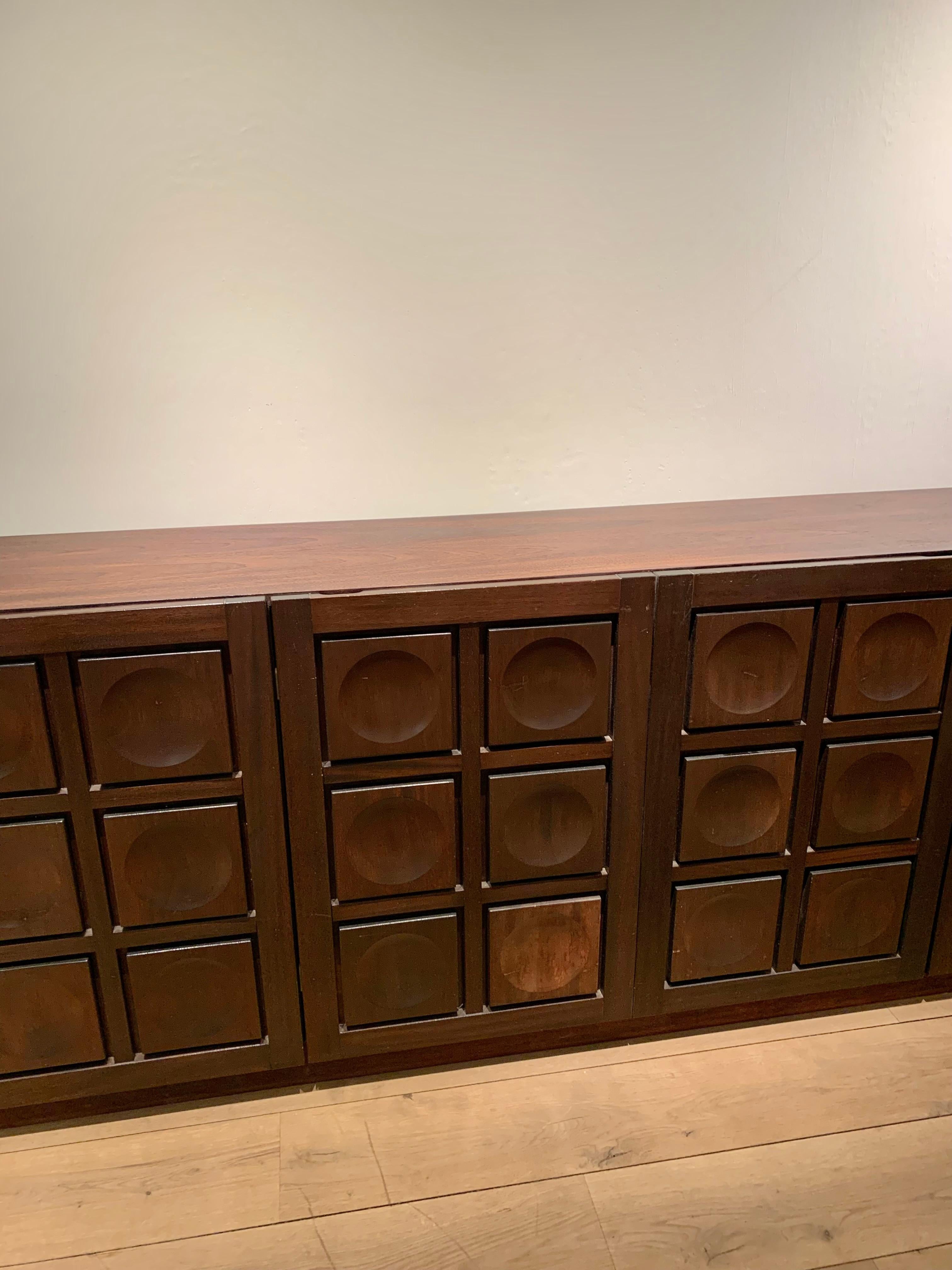 Fabulous large “mahogany” stained oak vintage brutalist French credenza - sideboard with decorative carvings on the five doors. The credenza is very spacious with long shelves for table cloths, napkins, tableware, etc. and has two drawers for