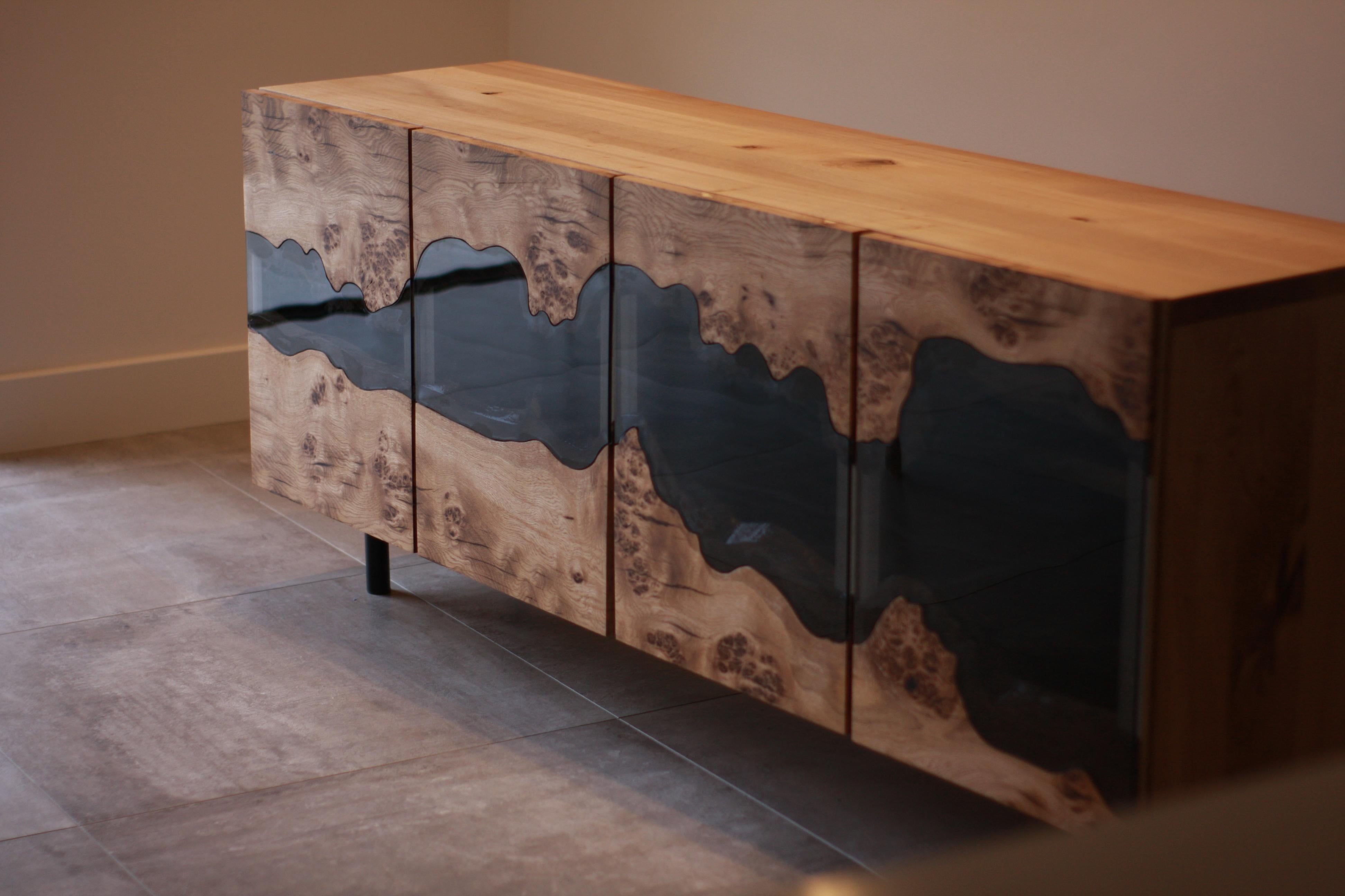 Here you will find a very special piece. A piece you will not find anywhere else.

This is the smoked glass inlay and oak credenza.
The oak doors are made from waney edge slabs of very sought after pippy burr oak - this is because for maximum effect
