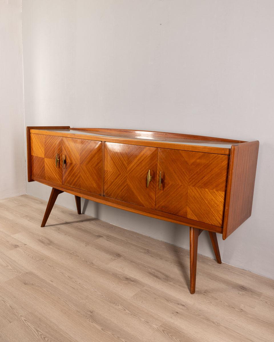 Credenza a quattro ante con struttura in legno e maniglie in ottone dorato, piano superiore in vetro, design Italiano, anni 50.

CONDIZIONI:
In buone condizioni, funzionante, può presentare segni d'usura dati dal tempo.

DIMENSIONI: 
Altezza 92 cm;