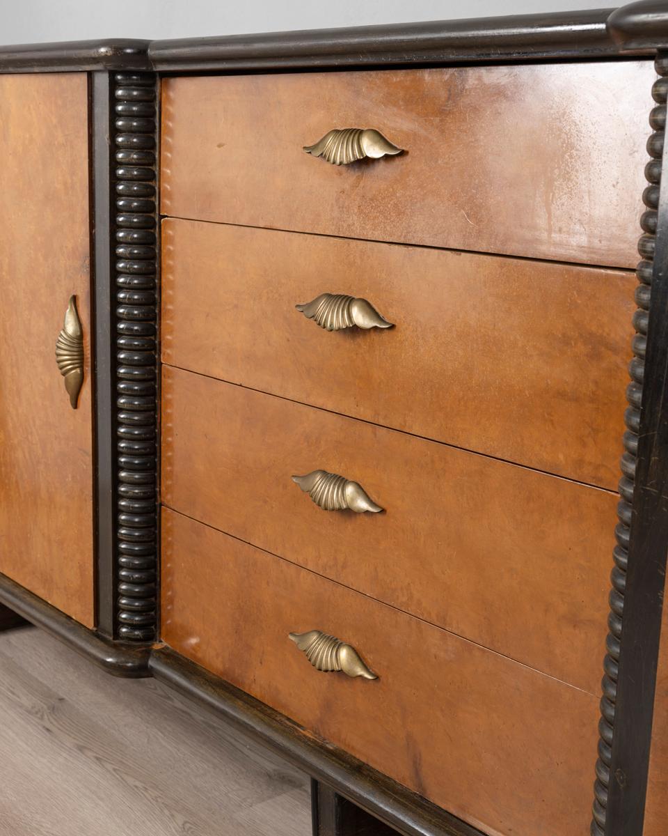 Credenza in legno di Noce e Radica con maniglie in ottone dorato e vetri specchiati e decorati, design Art Decò Italiano, anni 40.

CONDIZIONI:
In buone condizioni, presenta segni d'usura dati dal tempo.

DIMENSIONI: 
Altezza 97 cm; Larghezza 211