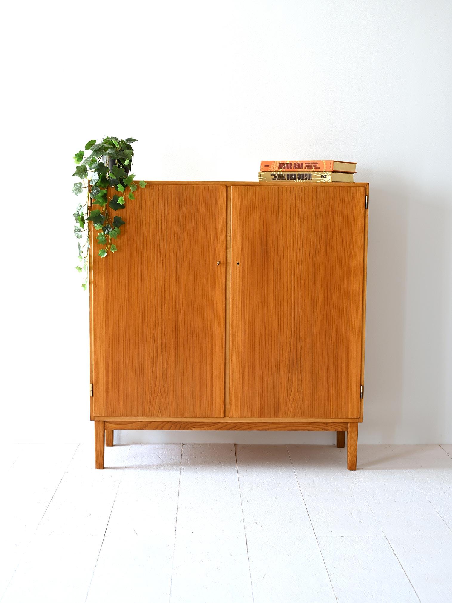 Scandinavian furniture with simple, square shapes, an example of practicality and refined design. Made of light wood with marked grain, it is distinguished by its lockable hinged doors, providing security and functionality.

Inside, the credenza is