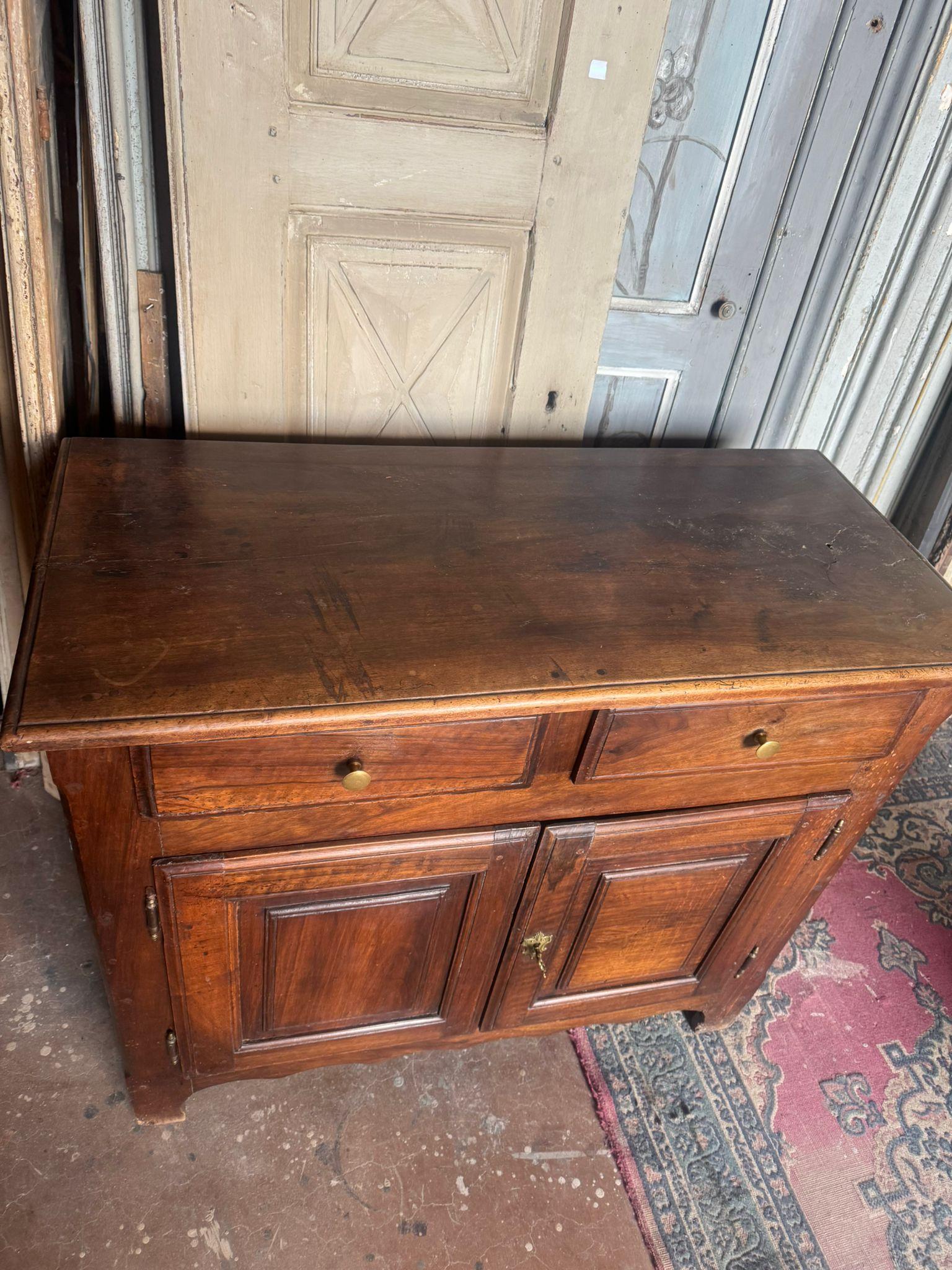 Credenza antica, mobile in legno, credenza in noce massiccio, organizzata con due ante e due cassetti, ha ripiani interni.
Molto elegante e raffinato, ideale in tutti gli interni, di origine italiana e originale del XVIII secolo. Misure cm L 107 x H