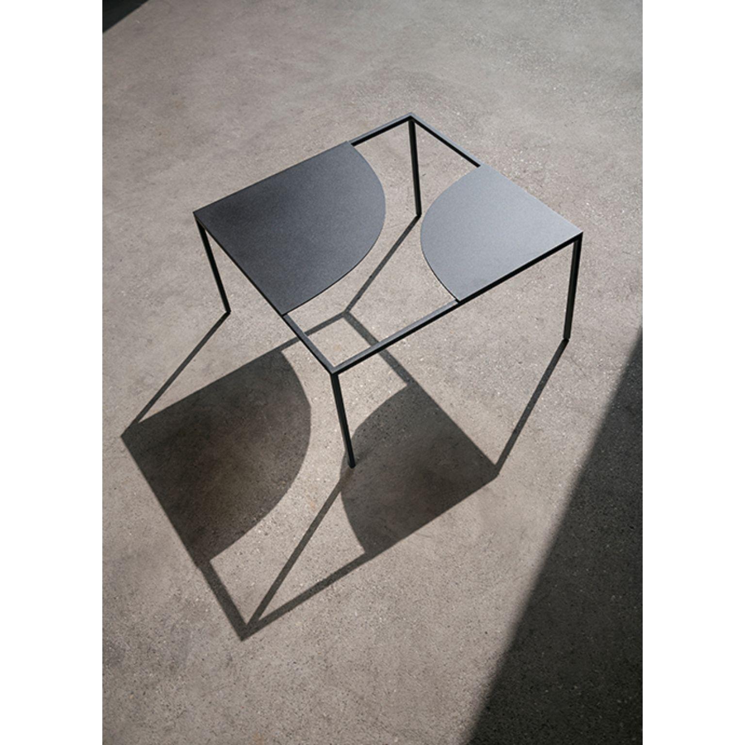 Creek coffee table by Nendo.
Materials: Top: Powder coated metal (Also available in solid wood)
 Structure: Black chrome metal
Dimensions: W 60 x D 60 x H 31.7 cm.

Creek is a table that suggests a stream of water flowing freely across its
