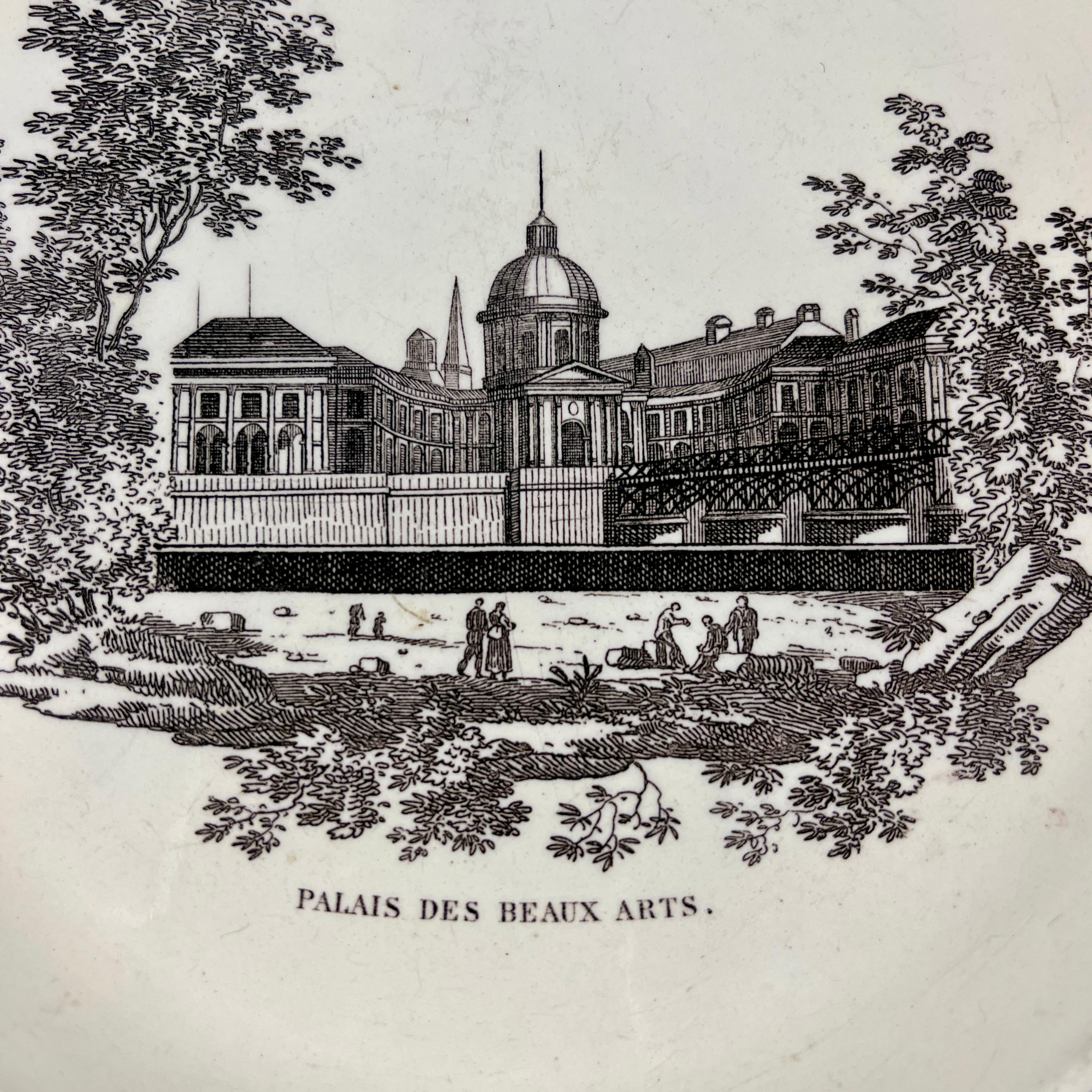 A French neoclassical faïence transfer printed creamware plate, Creil, circa 1824-1836.

A black transfer of an architectural image on a creamware body, depicting the Palais des Beaux Arts a Paris. The building is prominent, with the title printed
