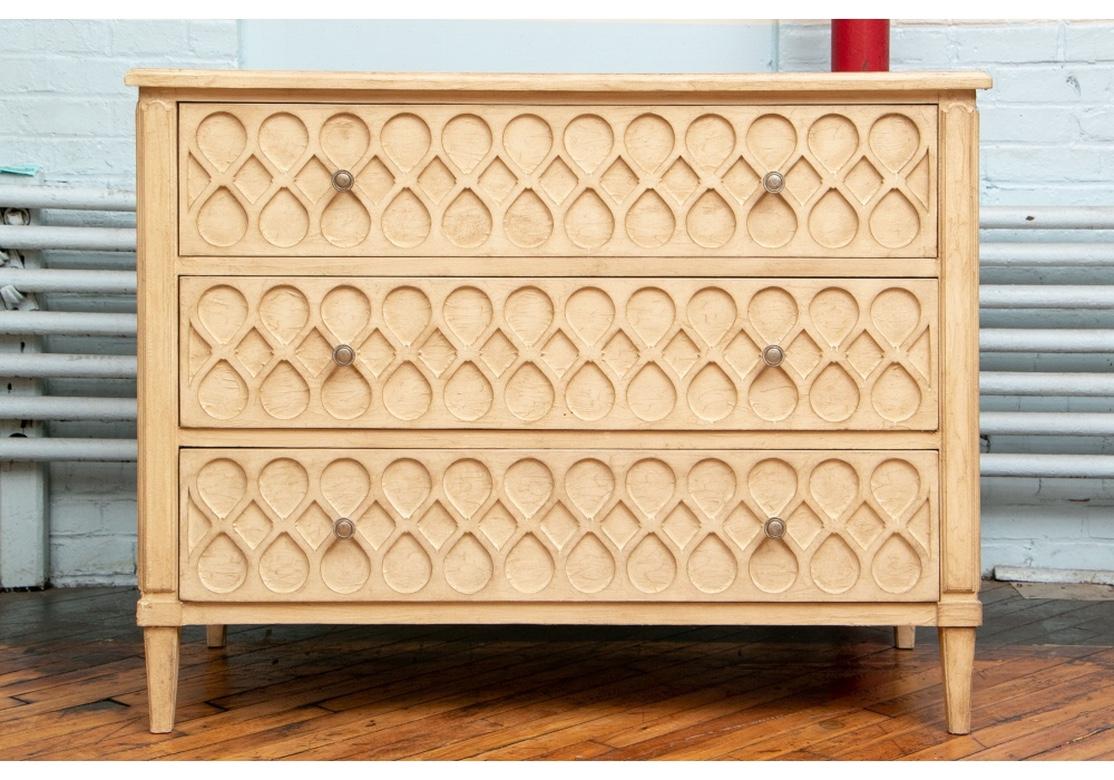 A large and very well made three-drawer chest with a textured surface in intentionally worn crème paint finish. The chest is highly decorative with a repeating and optic raised design in diamond and teardrop elements. The construction is very fine