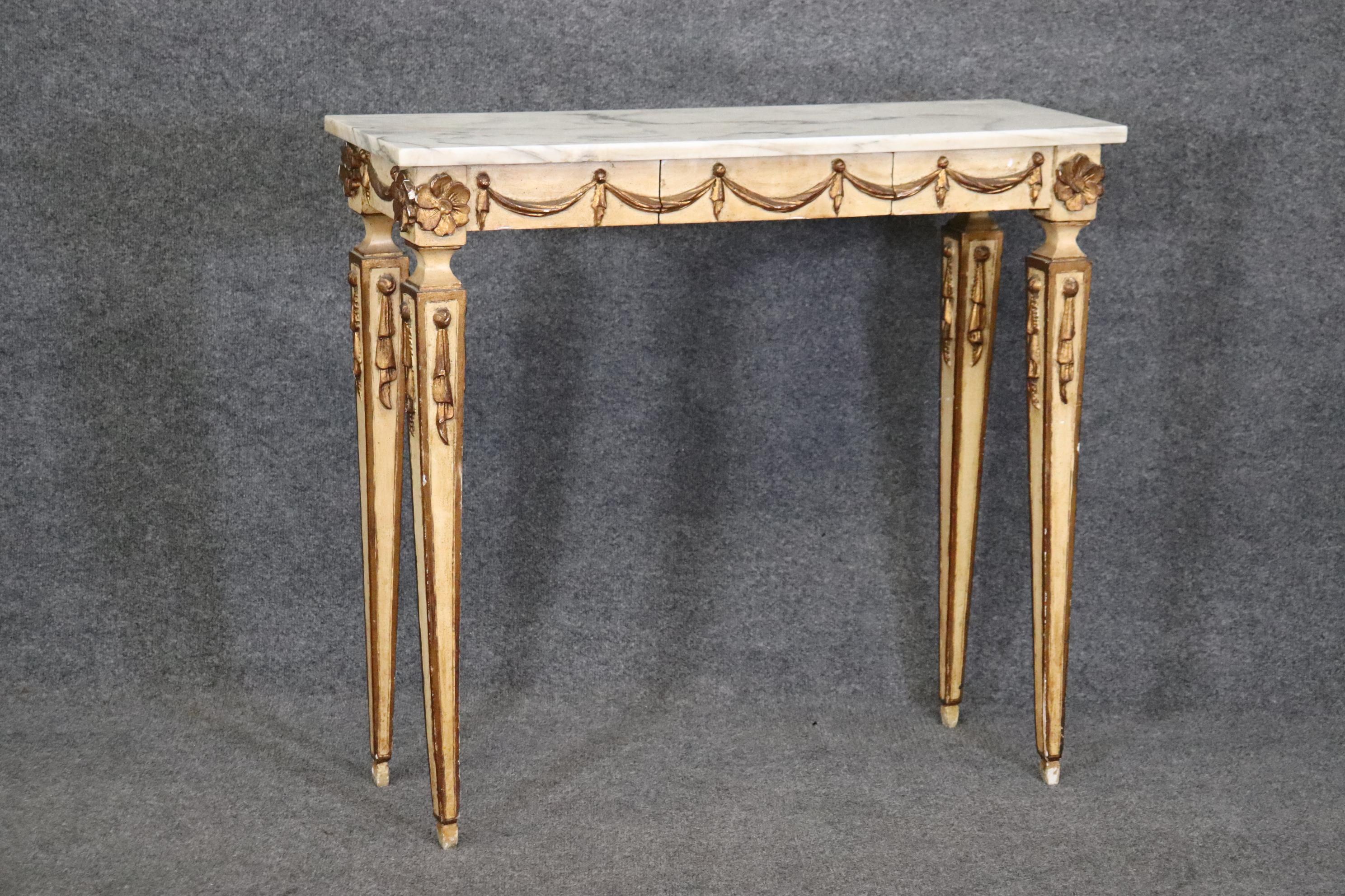 This is a gorgeous painted decorated 1950s era Italian-made console table with a drawer in the center. The table has its original creme painted surface and gold details. The table will show stains, signs of use such as chips, finish losses etc. The