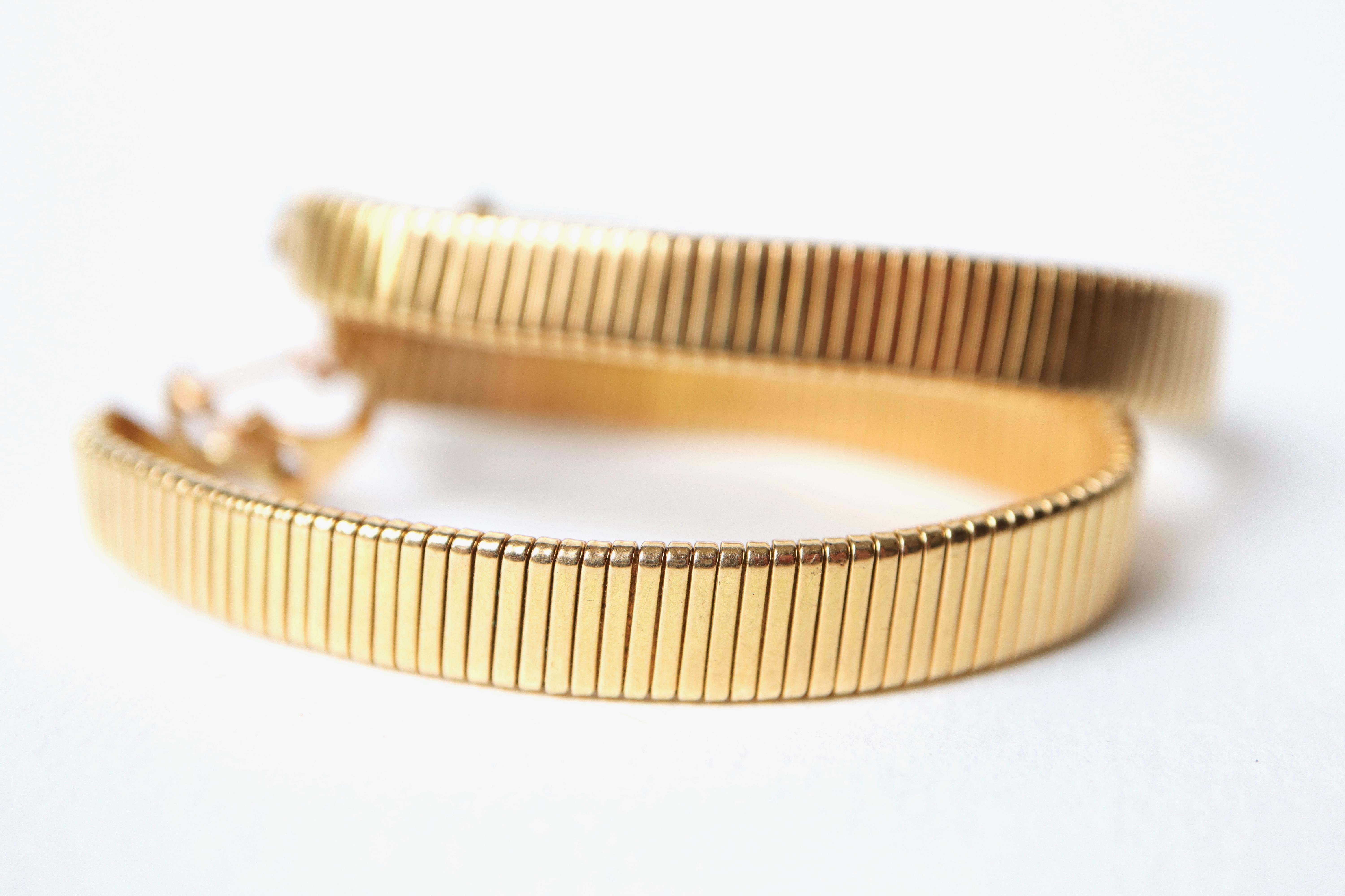 Boucles d'oreilles créoles en or jaune 18K, maille spirotube. La maille du spirotube est en bon état. 
Il forme quelques petites vagues ici et là, mais c'est encore très léger. Veuillez consulter les photos. 
Poinçon de la tête d'aigle.
Pour les