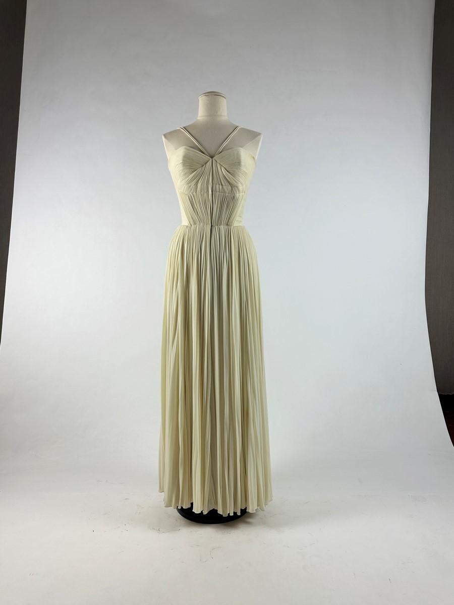 Spring Summer 1955

Paris

Crepe evening dress by Madame Grès Haute Couture (attributed to) from the Spring Summer 1955 collection. Draped long dress in ivory silk crepe, with large back neckline held in place by two thin straps, immortalized by