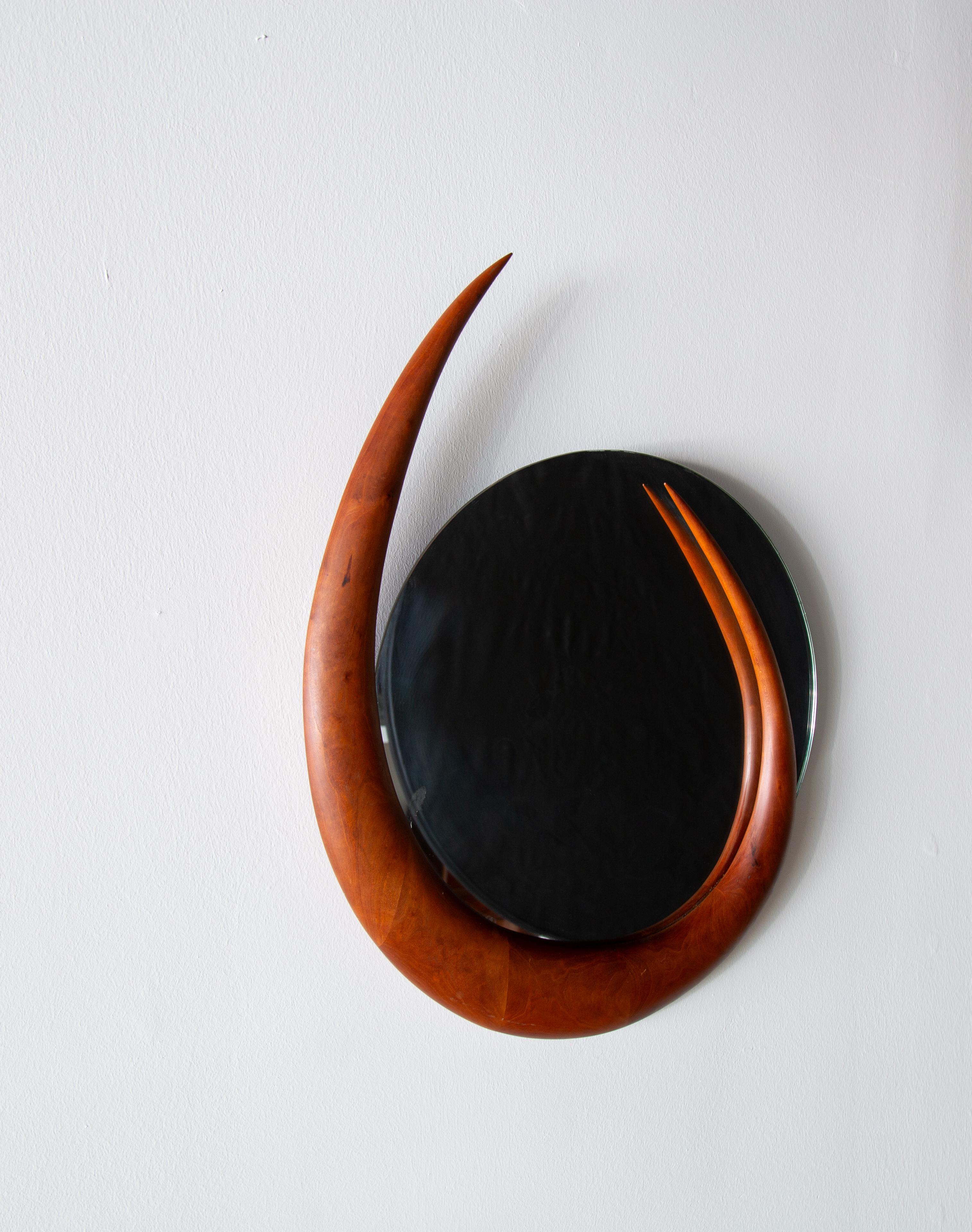 A studio craft Mirror by Kellams in solid hand carved walnut. Signed and dated 1992. A sculptural frame set off of a thin round mirror gives a floating allusion. Well constructed in the manner of Wendell Castle. 

Dimensions:

Mirror is 18”