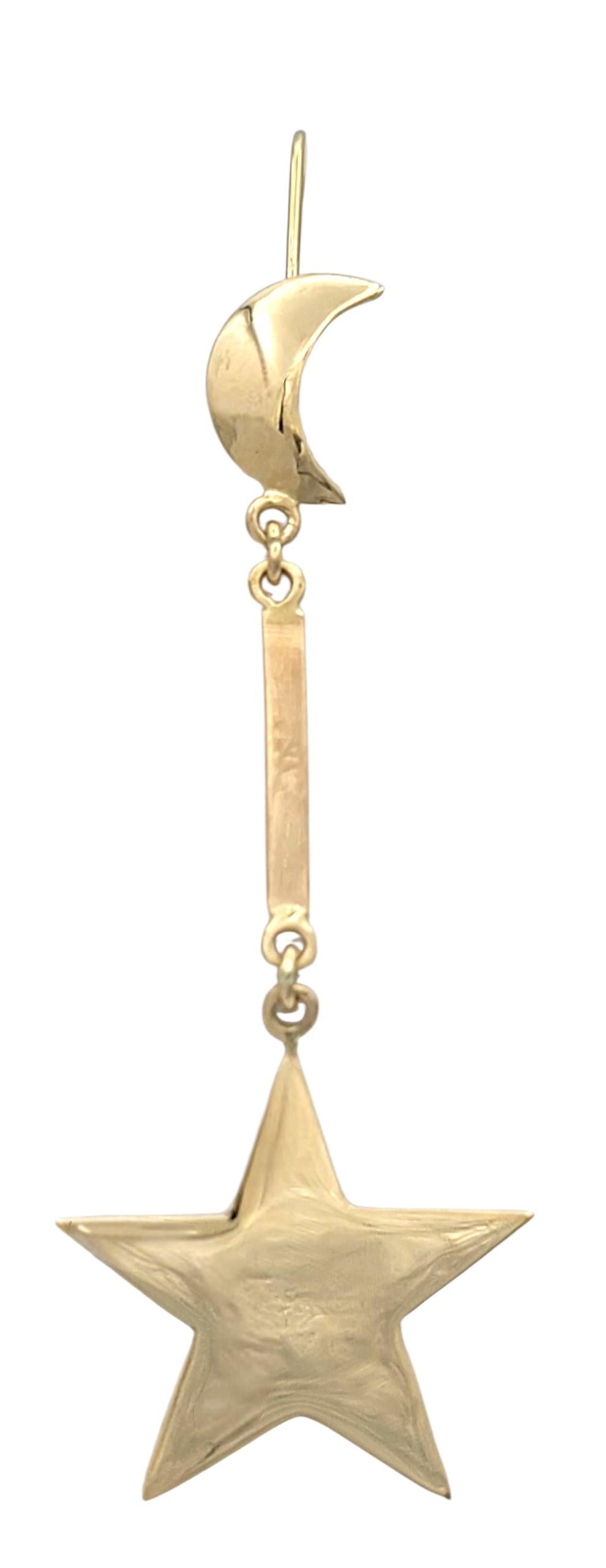 Questi divertenti orecchini a goccia presentano un affascinante design celeste con una mezzaluna in alto e una stella sospesa in basso. Le lune sono lucidate con una brillante lucentezza dorata, mentre sottili barre verticali le collegano alle