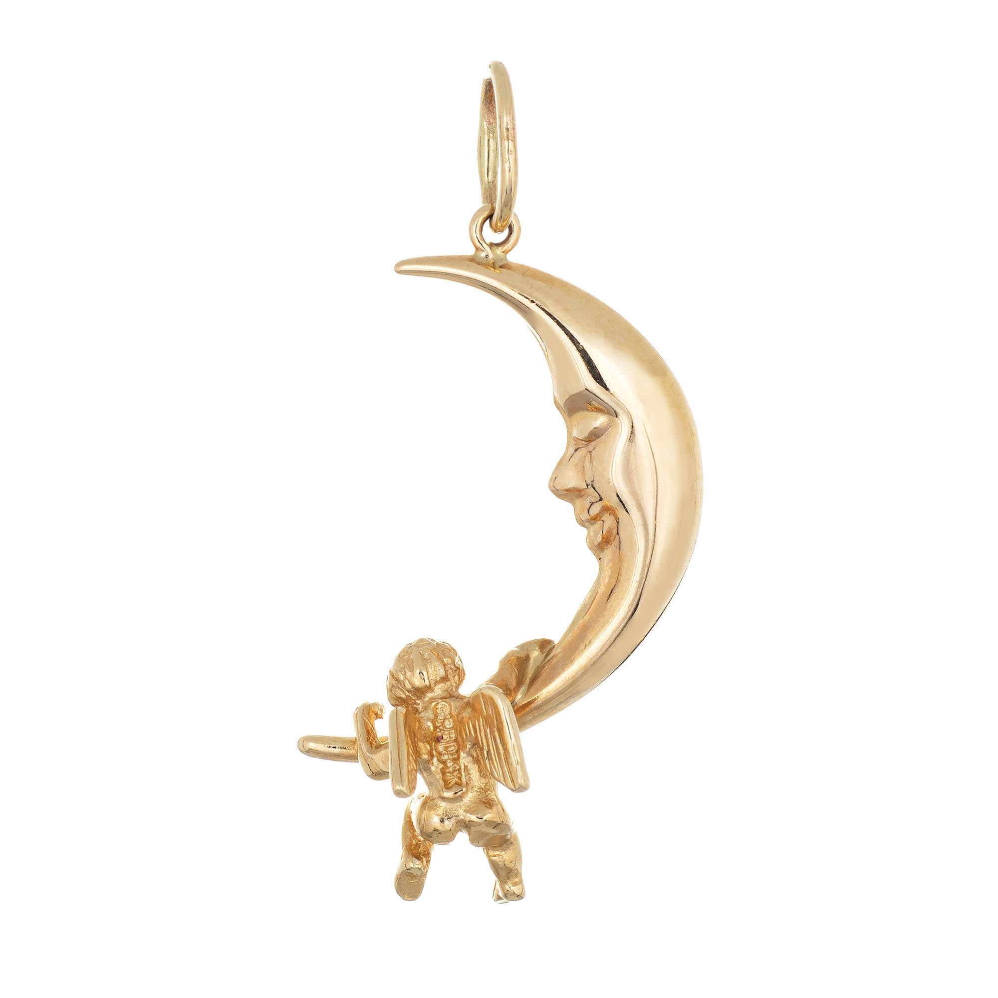 Finely detailed estate crescent moon charm crafted in 14k yellow gold.  

The charm features a man in the moon with a winged angel hanging at the base. Ideal worn as a charm on a bracelet or as a pendant on a chain. 

The charm is in very good