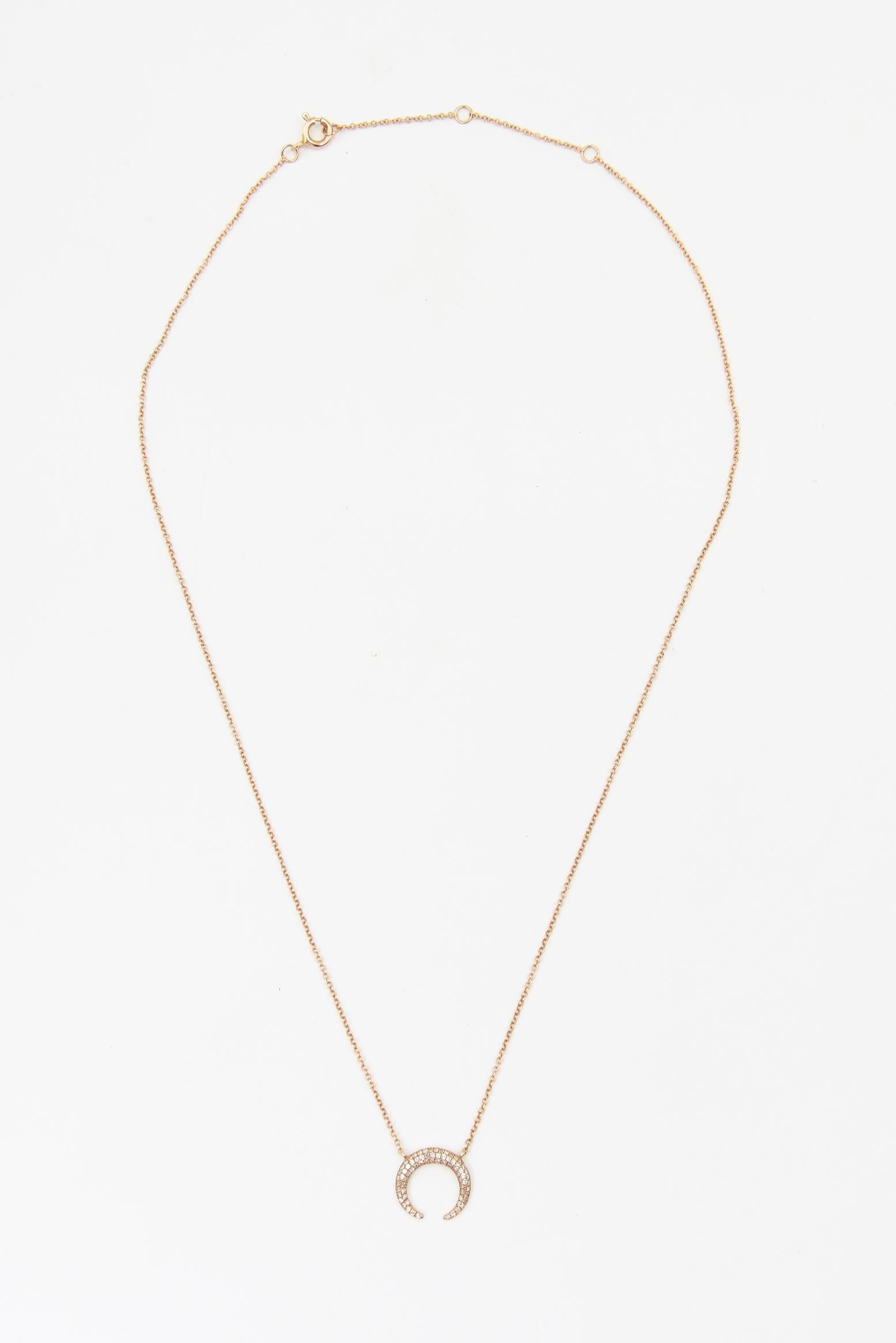 Cet élégant collier présente un pendentif en forme de croissant de lune réalisé en or rose massif 14k et orné de diamants sertis en pavé totalisant environ 0,25 carats. Le design/One, d'inspiration céleste, symbolise les nouveaux départs et la