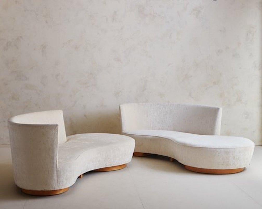 Un canapé iconique en forme de croissant conçu par Vladamir Kagan en 2005. Ce canapé présente un profil incurvé remarquable, avec un pouf sur le côté droit et un dossier surélevé sur le côté gauche. Il repose sur deux socles ronds en bois de chêne