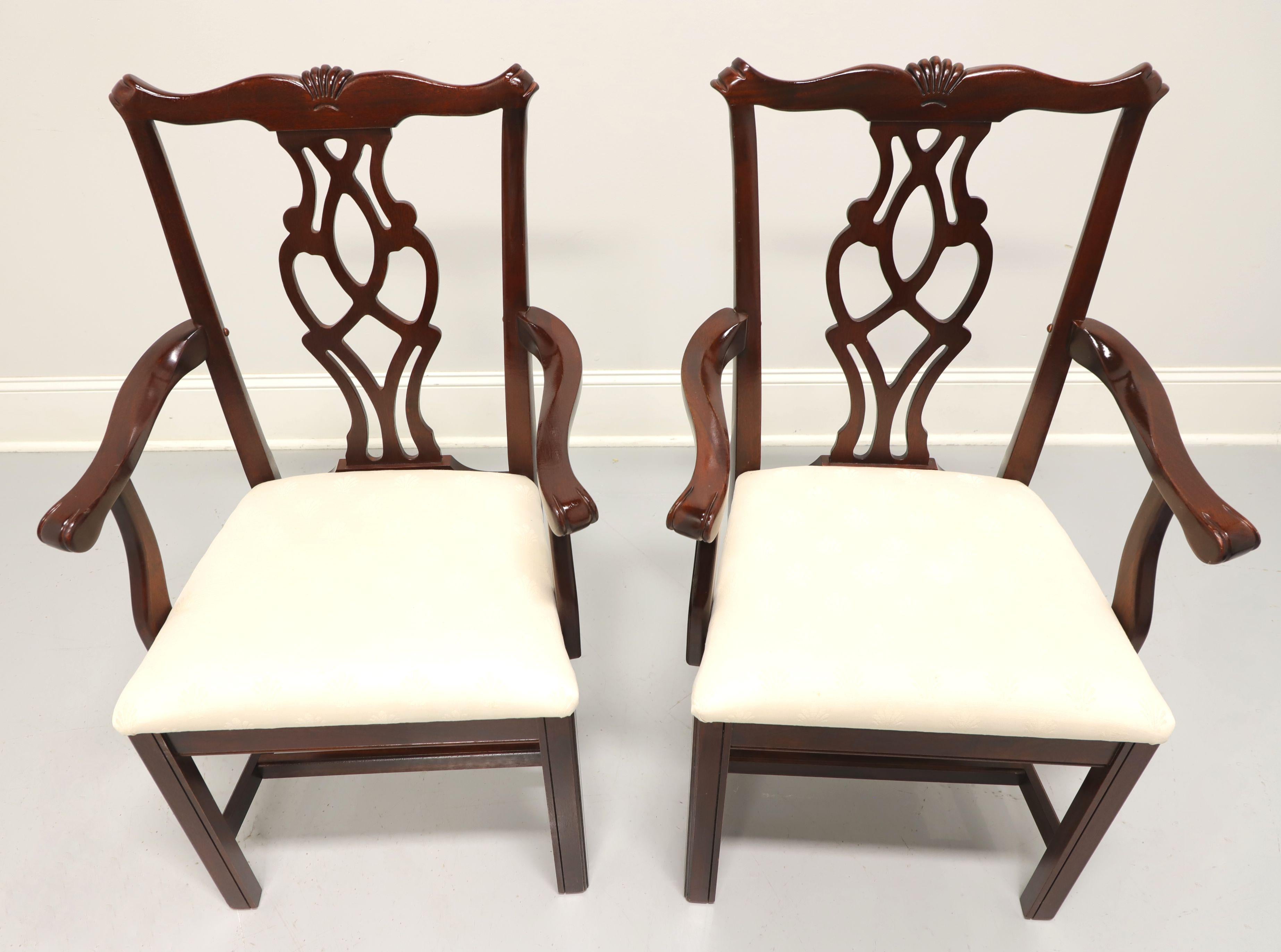A pair of dining armchairs in the Chippendale style by Cresent, of Gallatin, Tennessee, USA. Mahogany, with fan carving to crestrail, carved backsplat, curved arms, neutral cream colored brocade fabric upholstered seat, straight legs and stretcher