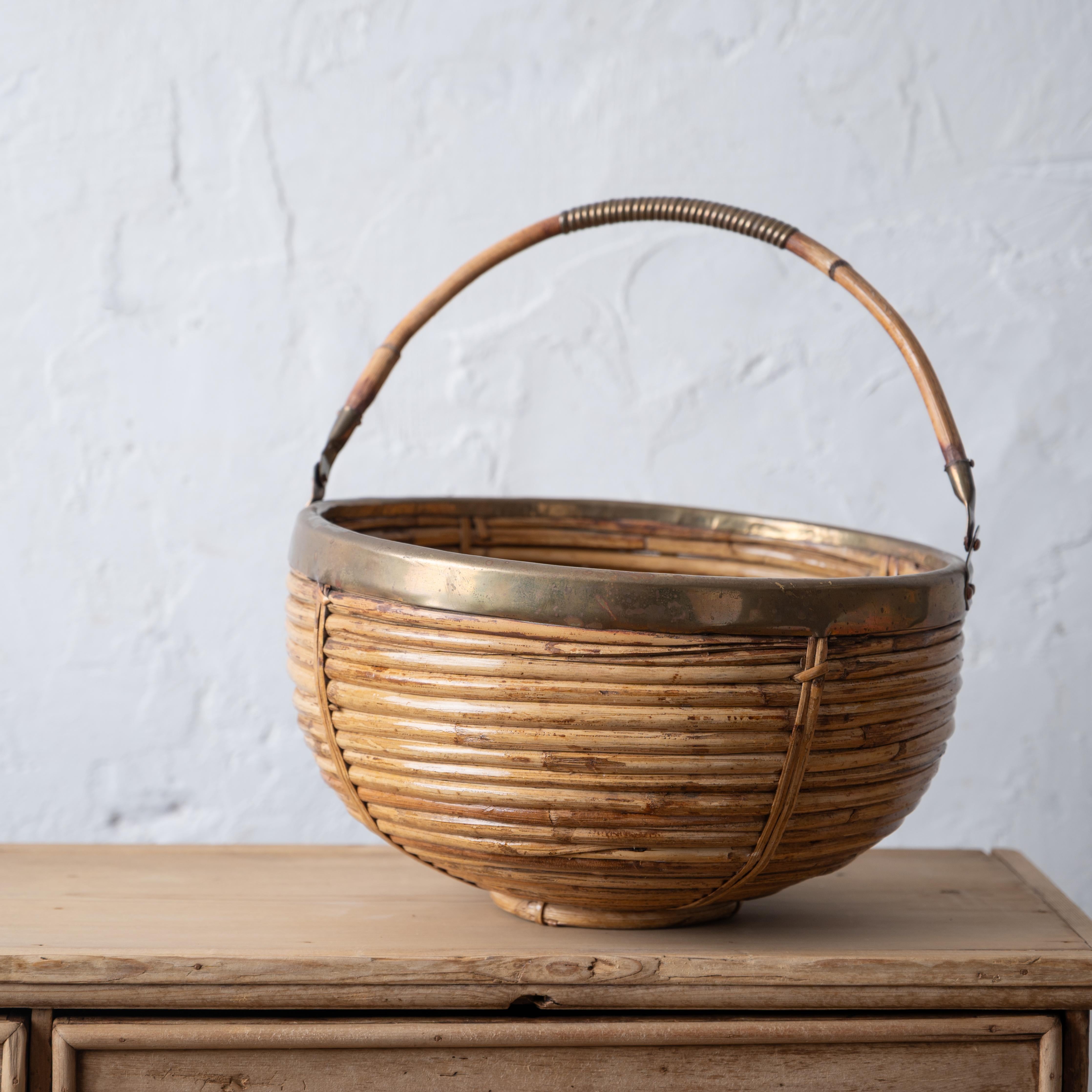 A Crespi style pencil reed and brass basket with handle, 1960s.

12 ½ inches wide by 12 inches deep by 8 inches tall

