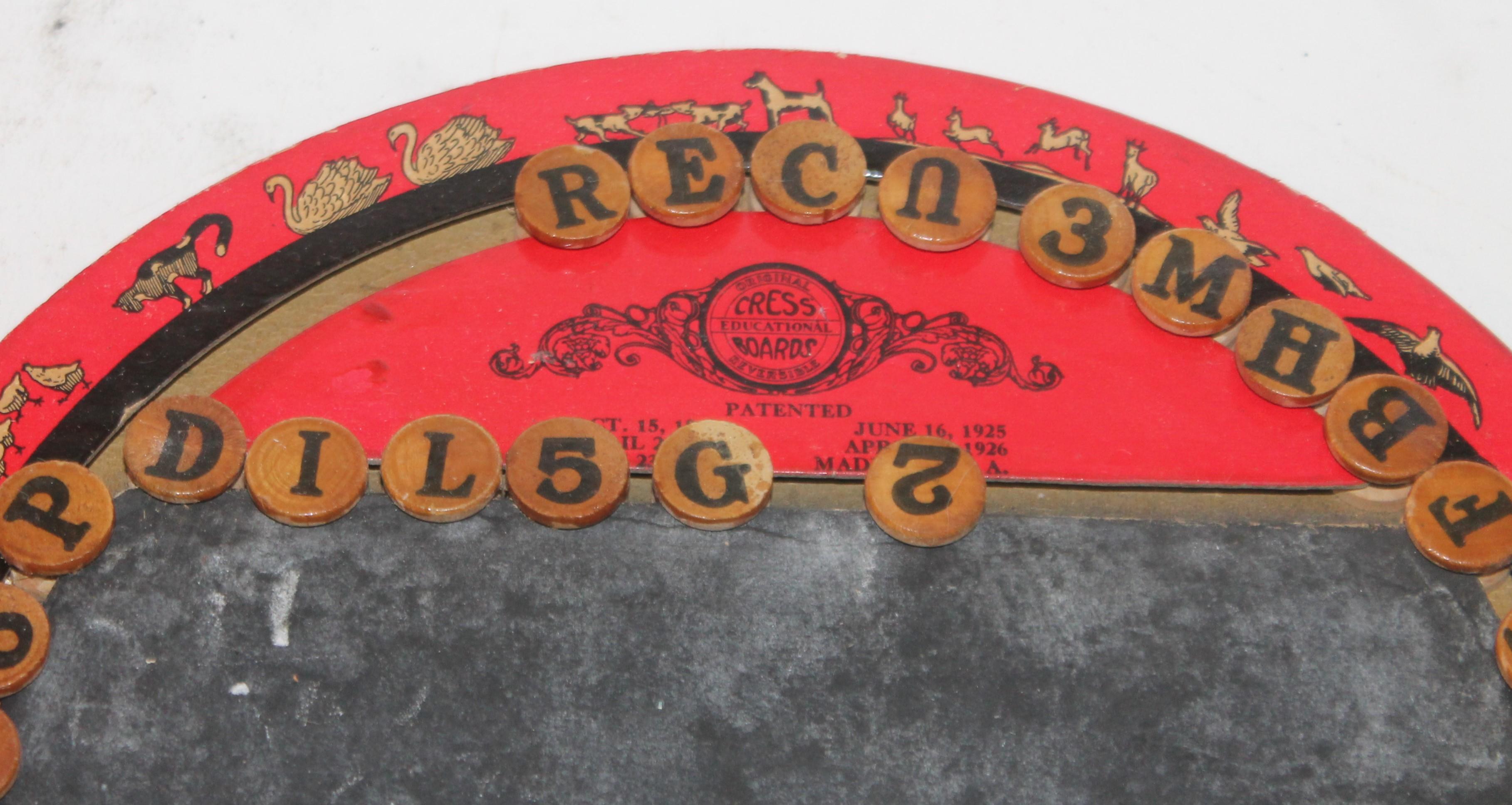 This cool cress alphabet game board is round and red ground. It is also dated 1926 with a chalk board on the front of the game board. Children pictures on the reverse of the board as well. Condition is very good.