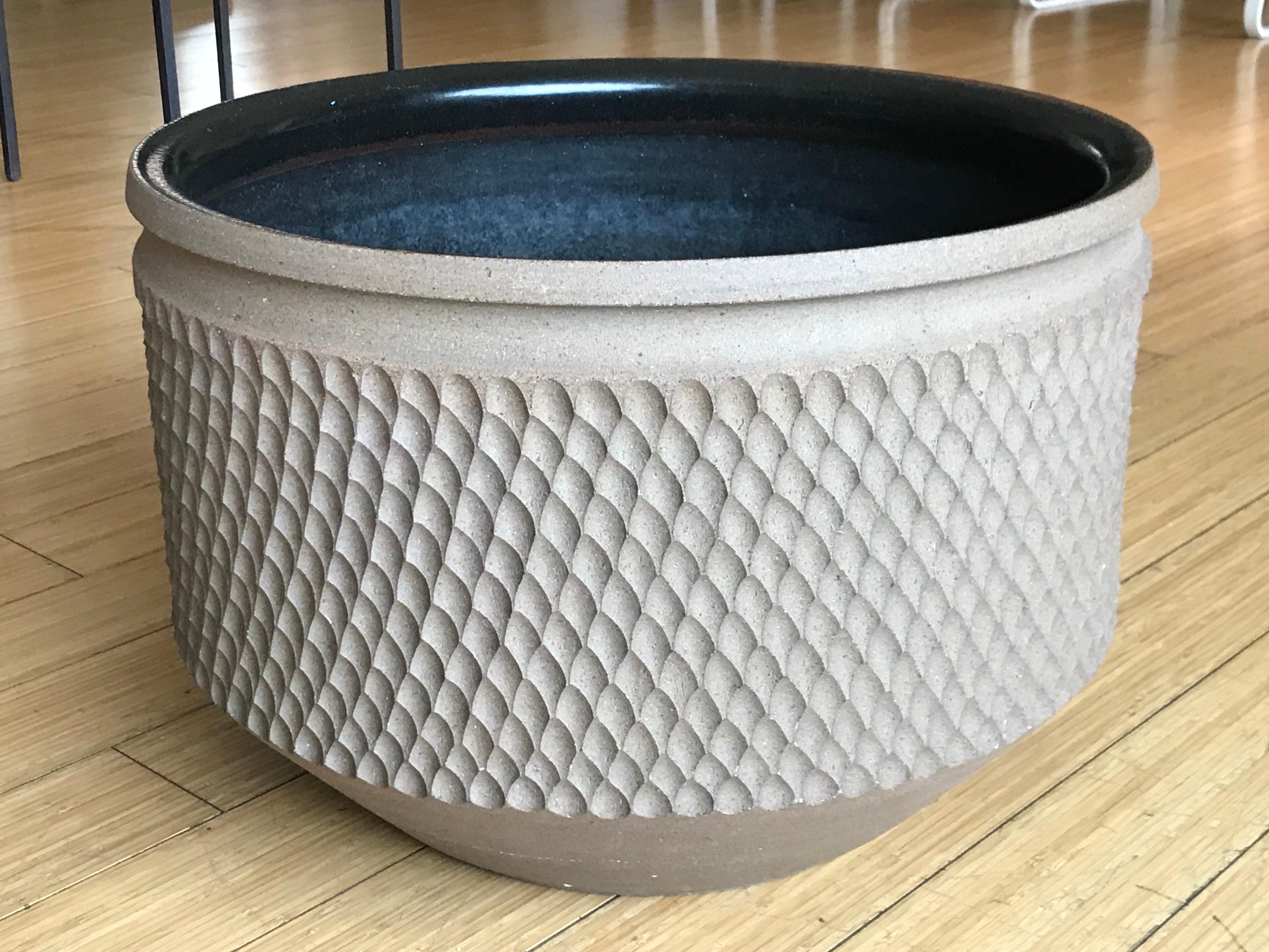 A great California design.
hand tooled pattern design on natural stoneware on the outside with black glaze on the inside
one or two minor chips, water drain holes and a tight hairline crack on the rim
other than that, it's in fine decorative