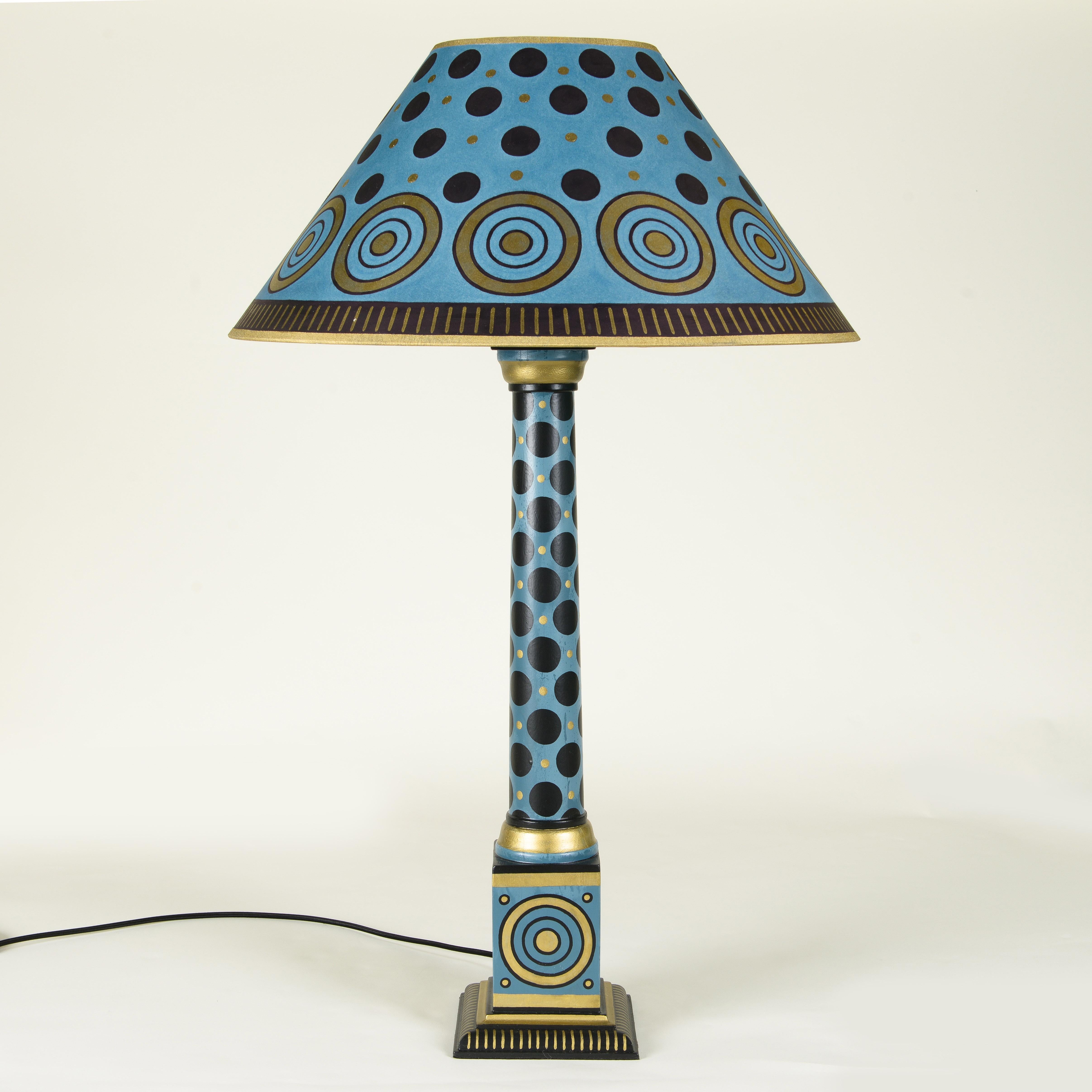 Pair of hand-painted column table lamps with a blue base color adorned with gold and black circular patterns.

Cressida Bell is a British designer specialising in textiles and interiors. From her London studio, she produces a wide range of products