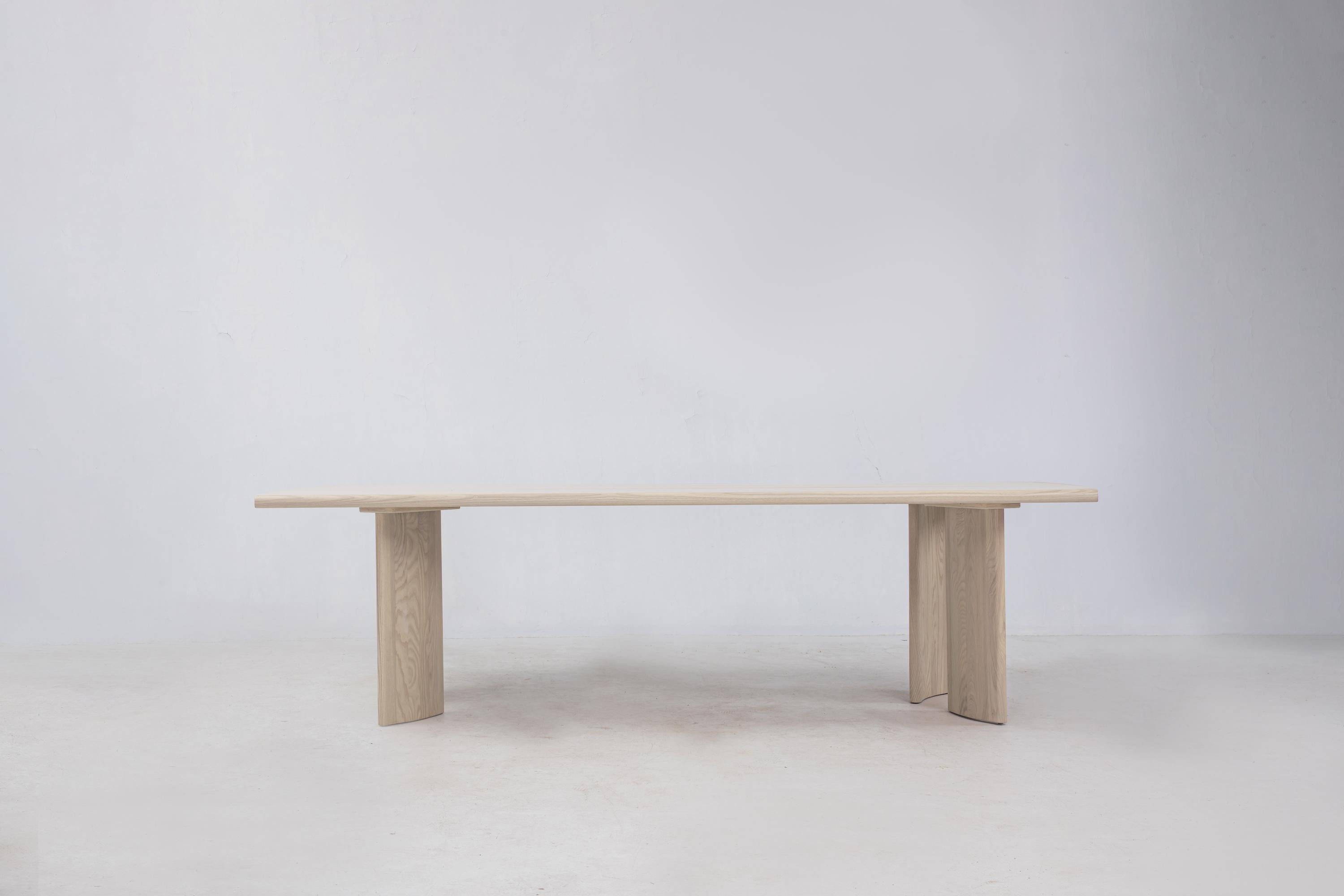 La table Crest est notre table de salle à manger en frêne blanc FSC. La lourde dalle en bois massif est posée sur des pieds en forme de colonnes incurvées et décalées. Nous avons conçu cette pièce avec des pieds détachés pour faciliter le
