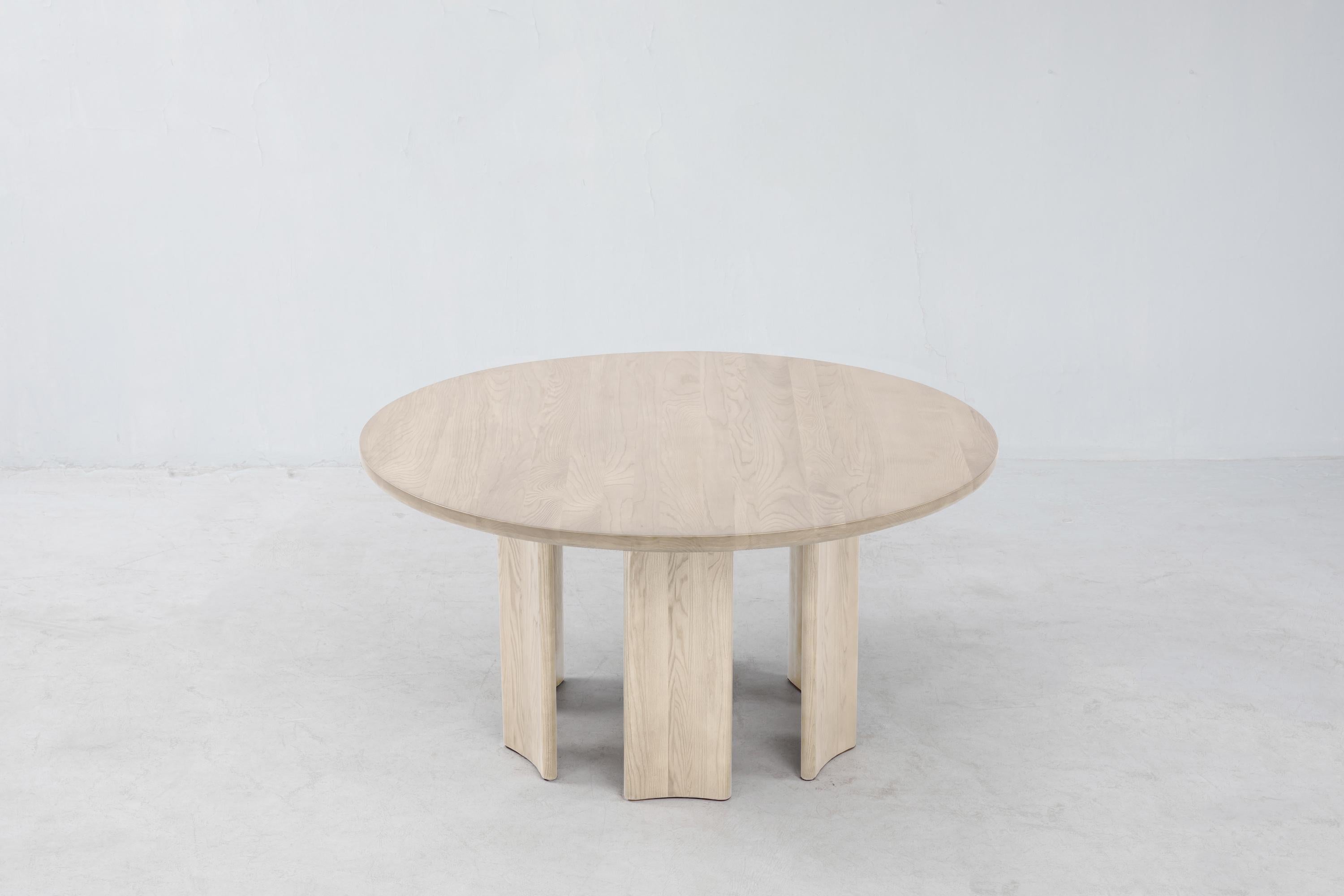 La table ronde Crest est une table de salle à manger en frêne blanc massif certifié FSC®. Comme pour la table Crest standard, les pieds concaves en forme de colonne sont inversables. Veuillez noter que nous fabriquons chaque pièce à la main et que