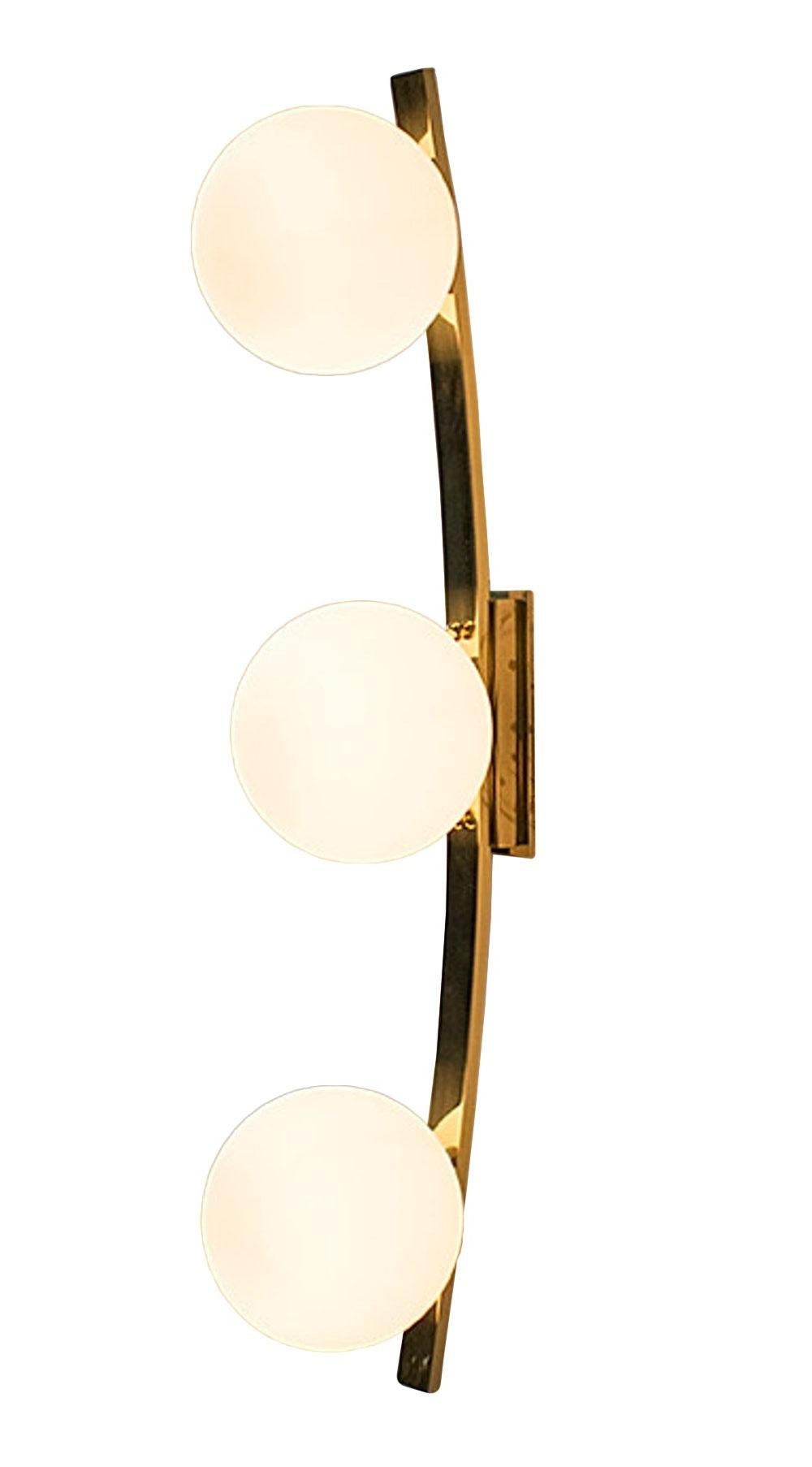 Italian wall light with hand blown matte white Murano glass globes, mounted on curved polished brass finish frame / Designed by Fabio Bergomi / Made in Italy
3 lights / E12 or E14 / max 40 W each
Measures: Height 31.5 inches / Width 6 inches / Depth
