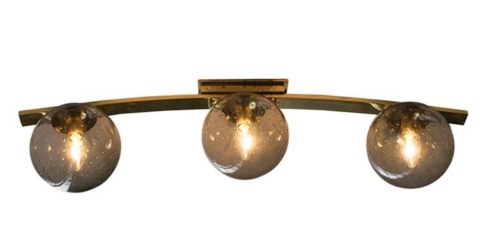 Italian modern wall light or flush mount with smoky Murano glass globes carefully hand blown with bubbles inside the glass using Bollicine technique, mounted on curved polished finish brass metal frame / Designed by Fabio Bergomi / Made in Italy
3