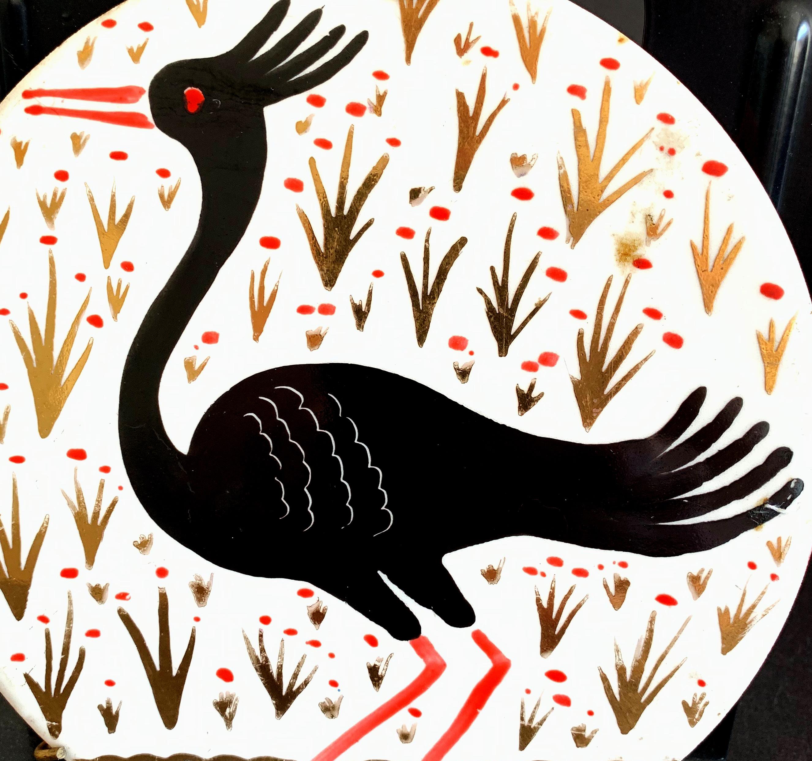 Rare et gagnant, ce joli rondel en porcelaine Art déco, émaillé de noir, d'or et de rouge sur un fond blanc, a été conçu et exécuté par Waylande Gregory, le grand sculpteur et céramiste américain. L'oiseau aquatique à crête représenté est exotique