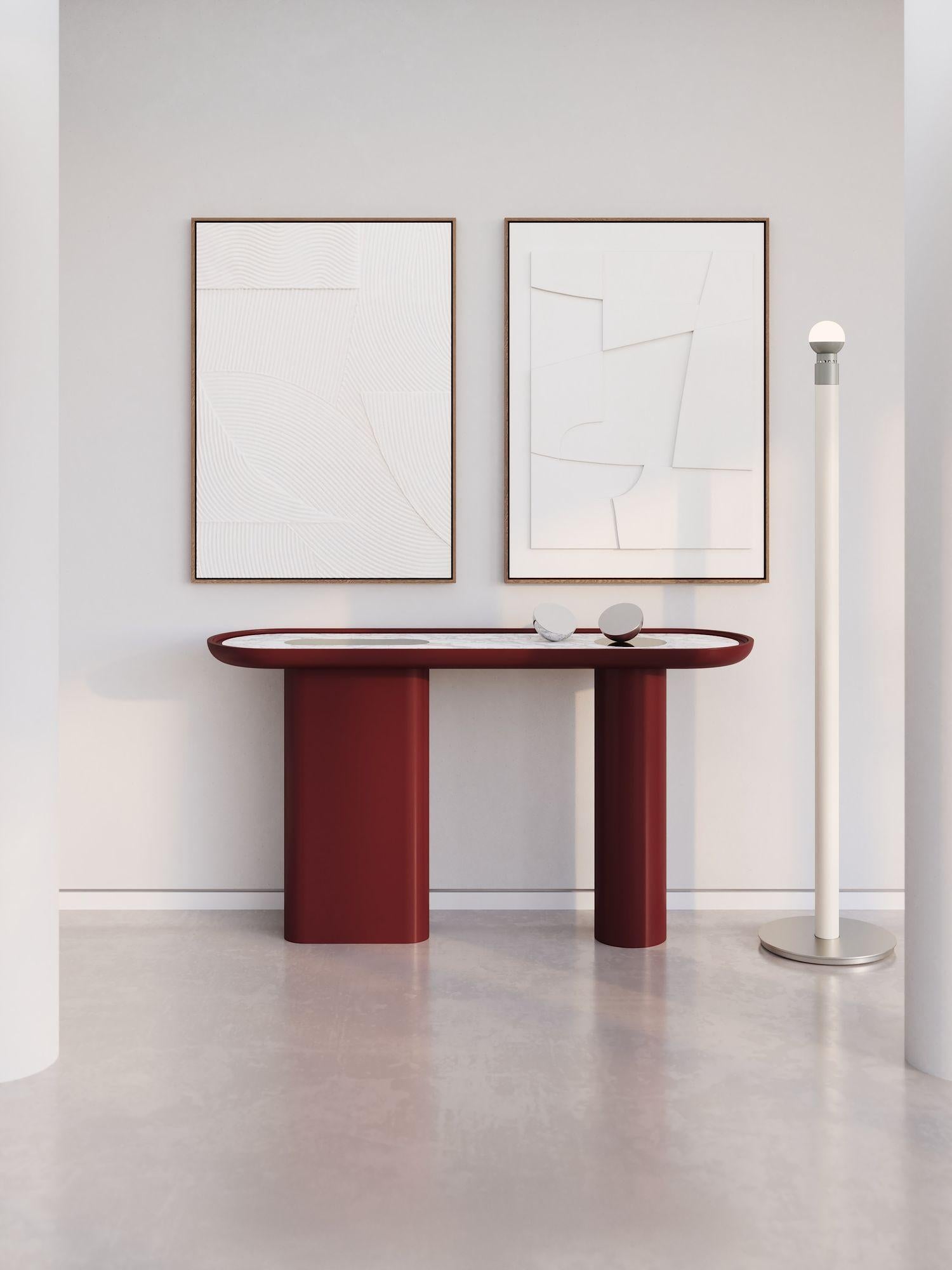 The sculptural, rounded shape and contrasting materials give maximum expressiveness to the Creta console.
Creta oval console presented in Wine Red matte lacquer finish with marble insert into the shaped top and inserted dichroic mirror elements.