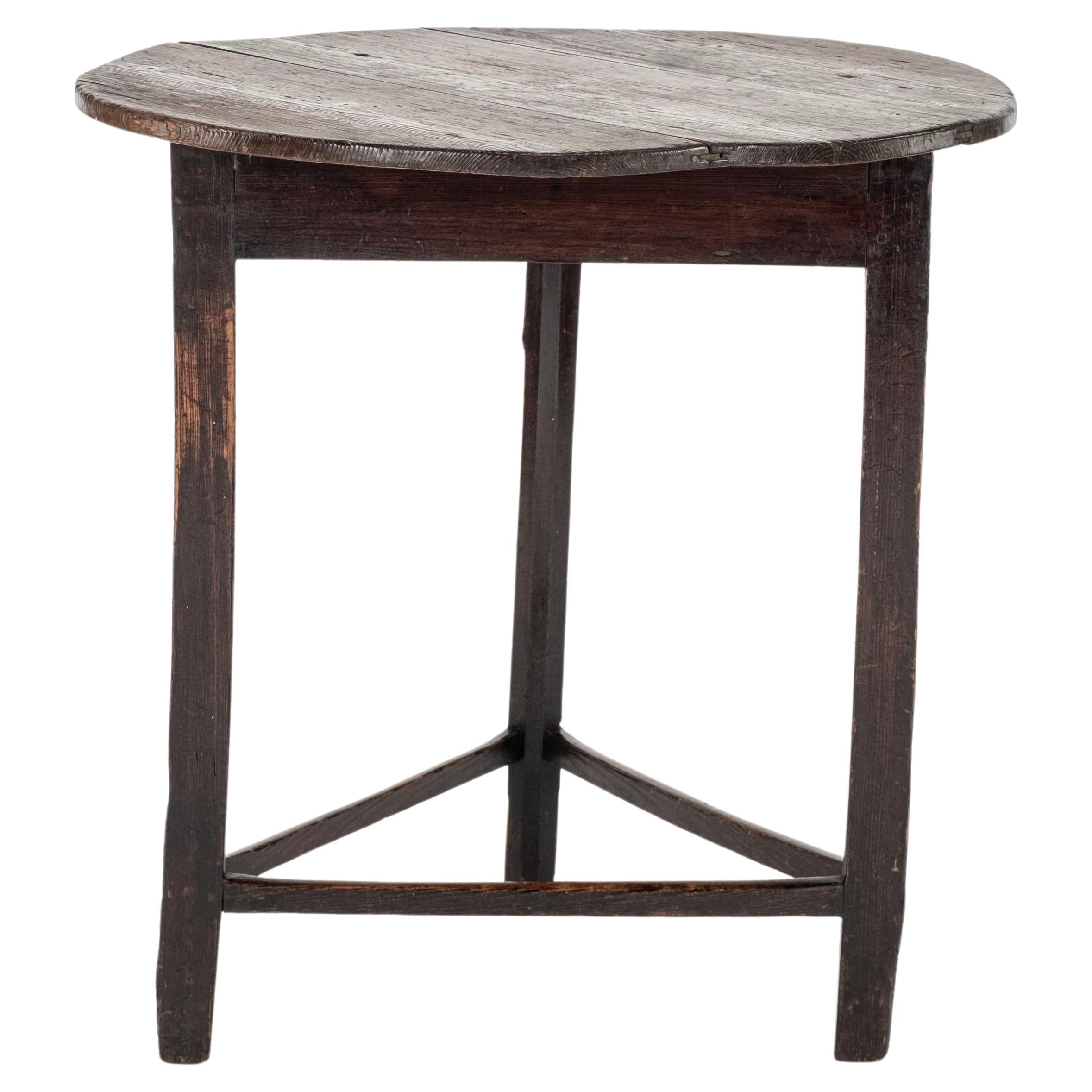 Mesa de cricket de pino del s. XVIII  con una camilla triangular debajo.