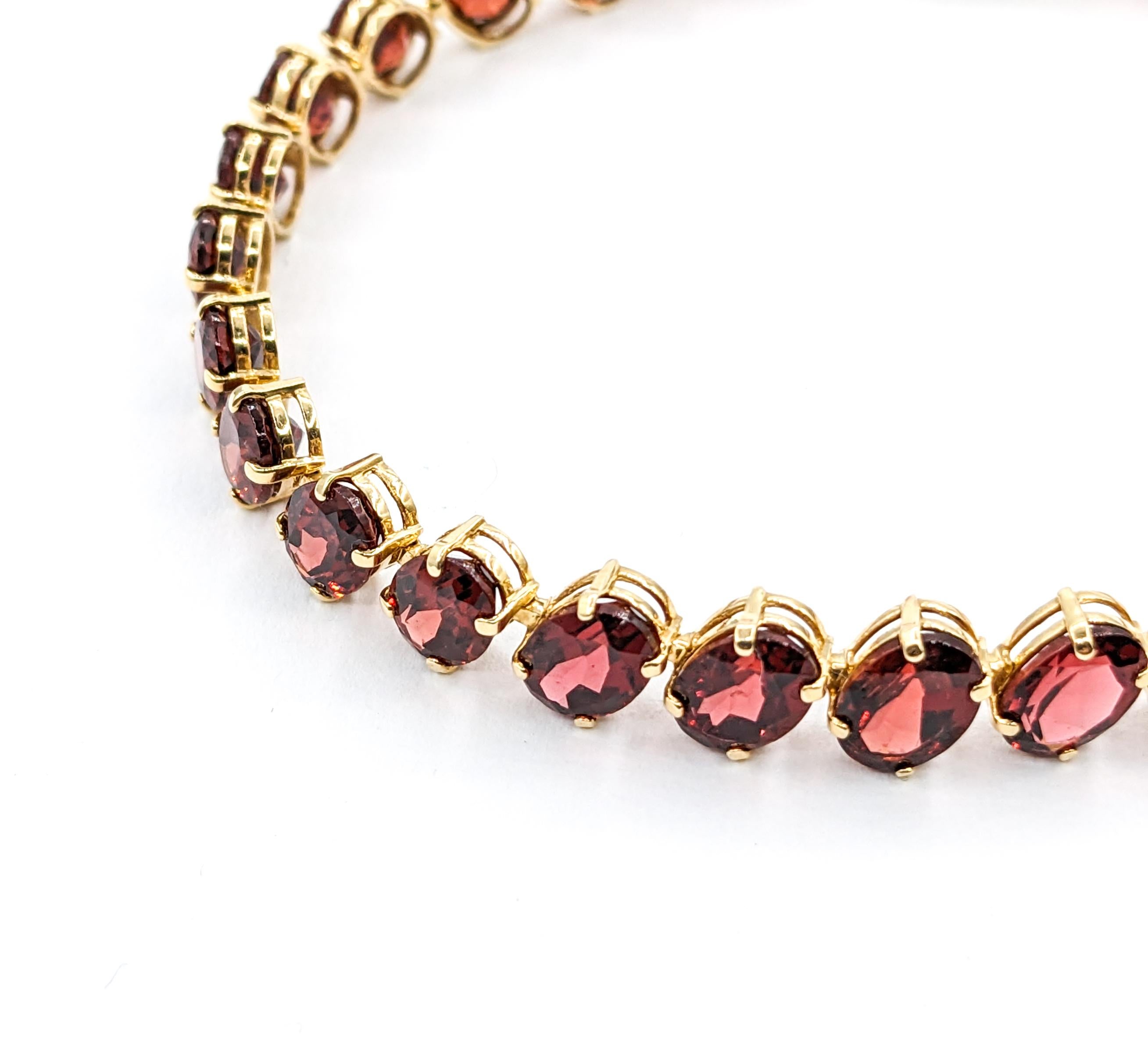 Crimson 26,6ctw Oval Granat-Tennisarmband aus Gelbgold

Dieses wunderschöne Granatarmband wurde sorgfältig aus 14 Karat Gelbgold gefertigt und strahlt Wärme und Luxus aus. Er ist mit beeindruckenden 26,6 ct ovalen Granaten besetzt, von denen jeder