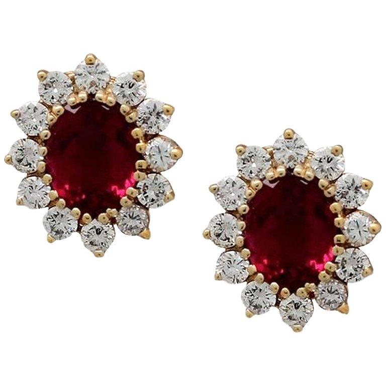Crimson Oval Tourmaline & Diamond Cluster Stud Earrings in 14kt Y/G
– Red tourmaline halo stud earrings
– Crafted in 14kt Yellow Gold
– Centered by 2 Oval shape checkerboard cut red tourmalines 4.50ct tw
– Surrounded by 2.40ct tw prong set round