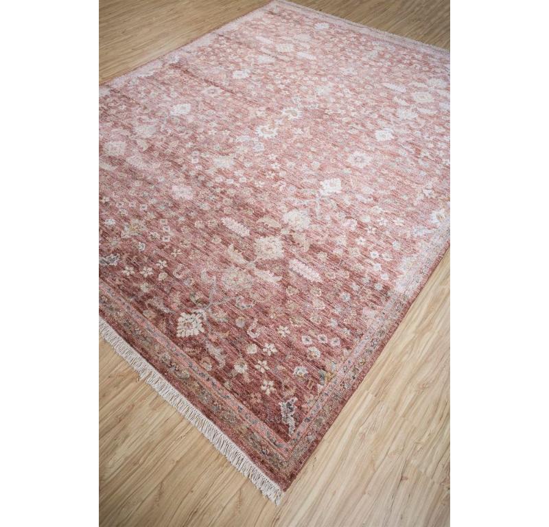 ¿Alguna vez has imaginado la riqueza del rojo vintage infundiendo calidez a tu espacio? Sumérgete en la elegancia de nuestra alfombra anudada a mano, donde el discreto follaje arabesco se entrelaza con delicados motivos florales. Elaborada mediante