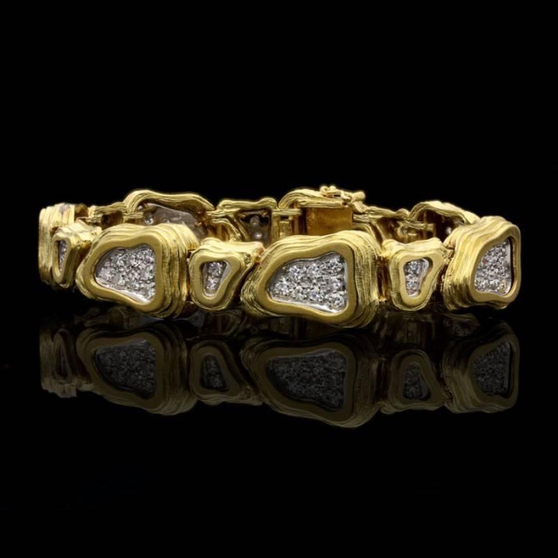A striking gold and diamond abstract bracelet by Crinnan 1975, designed as a row of alternating larger and smaller links of similar irregular triangular shape set horizontally and vertically, each composed of textured and stepped rows of 18 carat