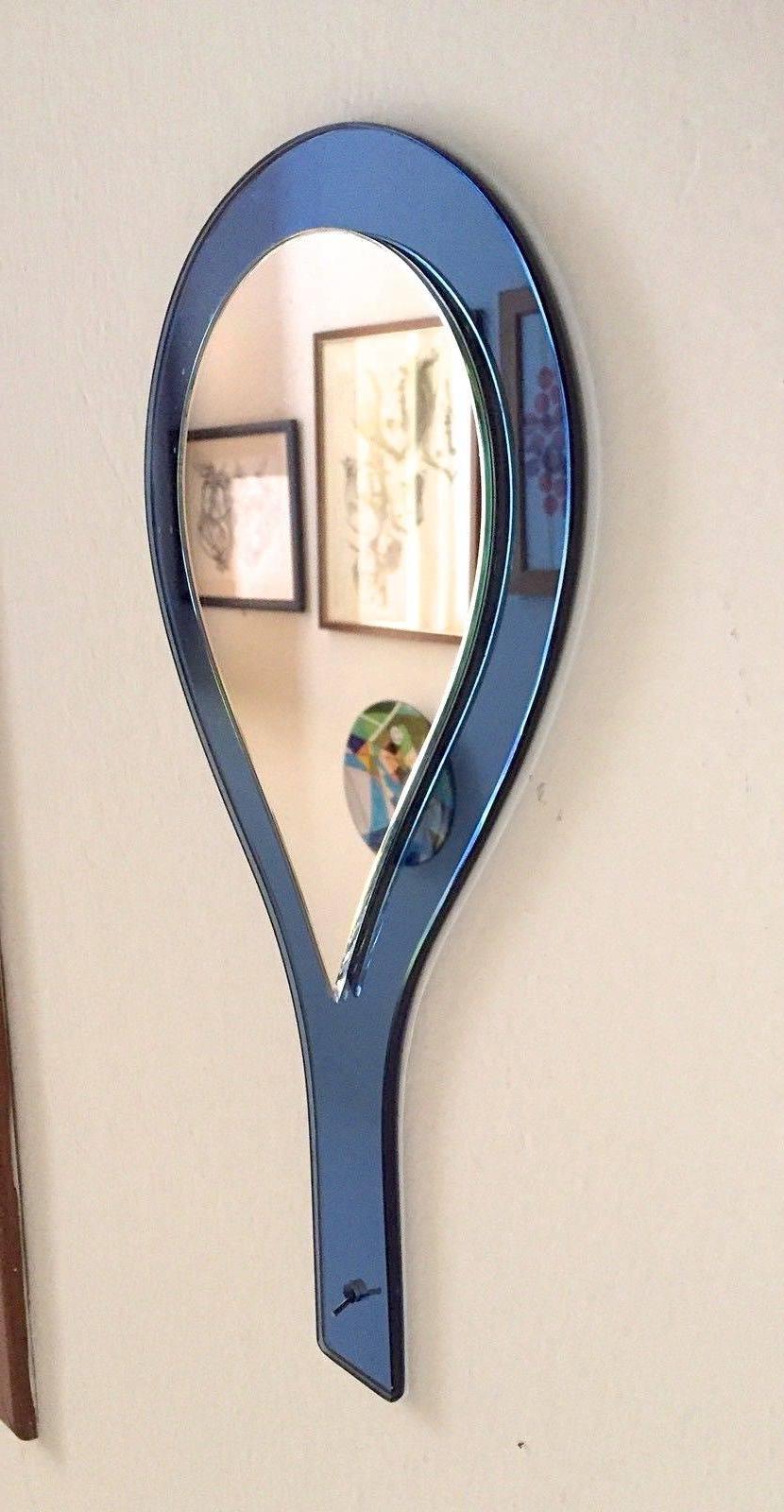 1960s Italian hand held vanity mirror by Cristal Art of Torino Italy.
Teardrop shaped silvered mirror on blue mirrored glass paddle with handle.
There is also has a small hole for hanging on a wall.
Verso is blue textured fiber backing.