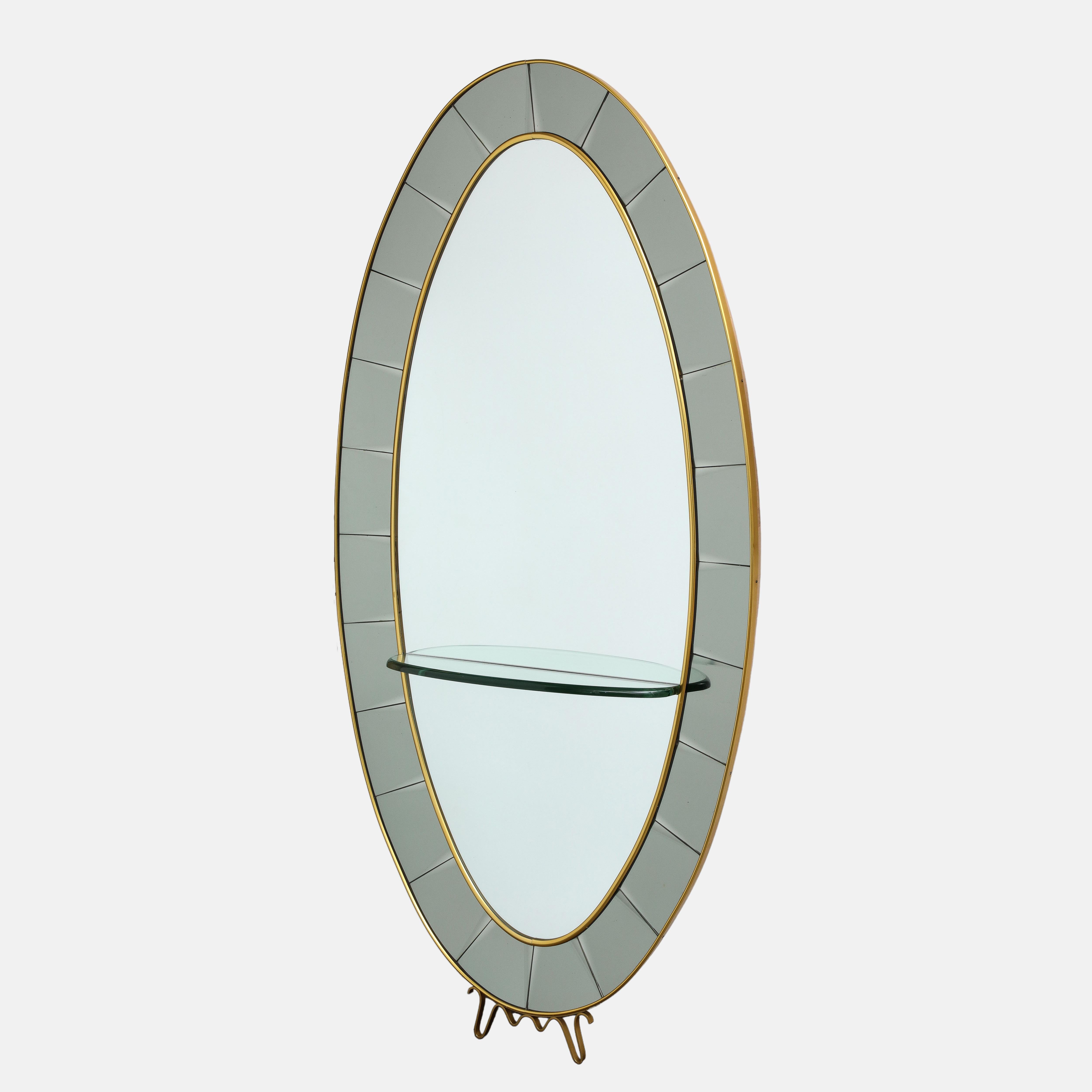 Cristal Art rare grand scale floor oval mirror model 2690 consisting of frame in hand-cut beveled colored crystal glass with gilt brass borders and lovely scroll detail below with thick clear crystal polished glass curved shelf. This exquisite and