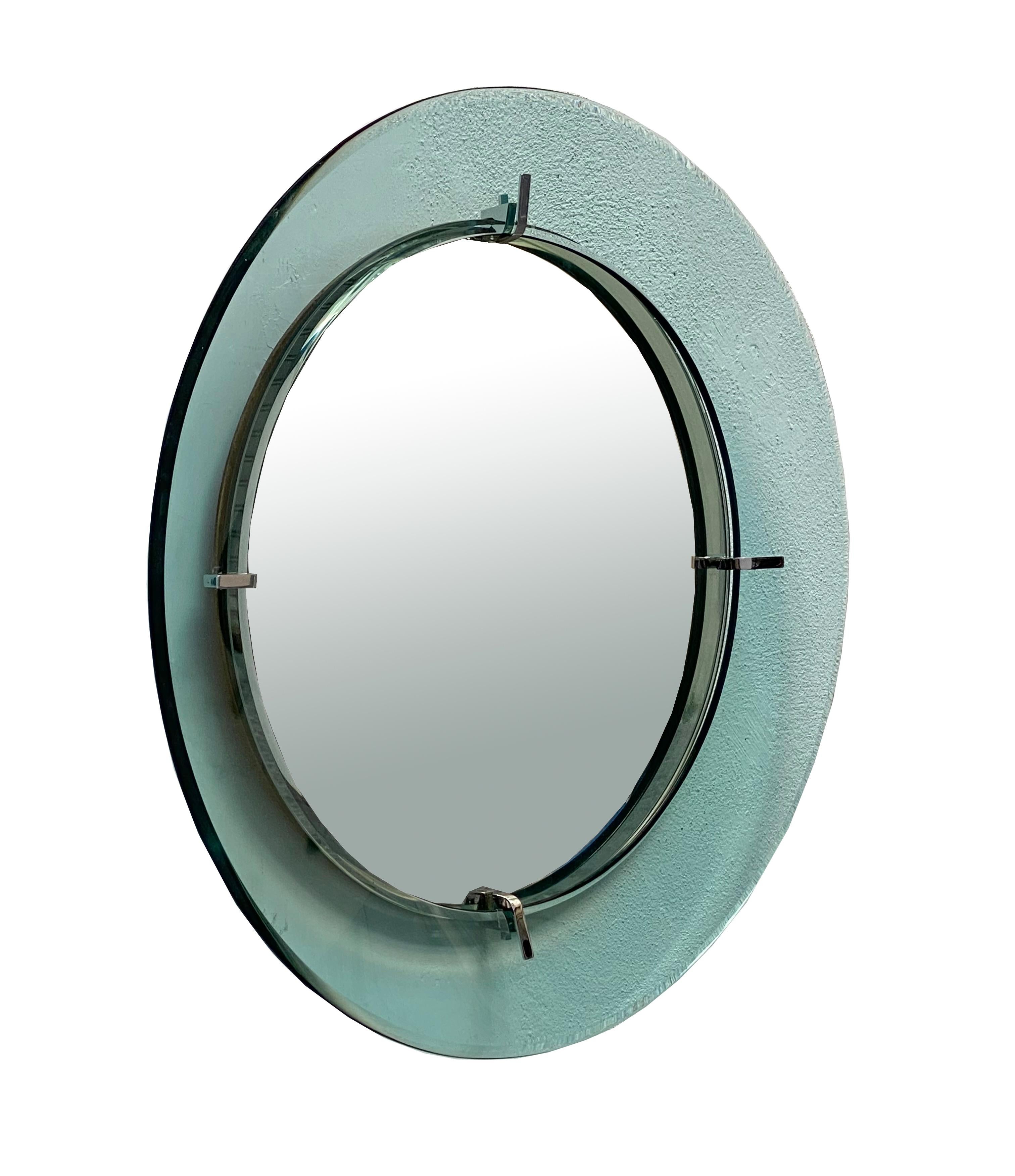 This round wall mirror was made in Italy around the 1960s. It consists of a wood and metal structure with a transparent green frame joined by 4 chromed metal supports. Remains in excellent condition. Few oxidation spots on the mirror near the edge.