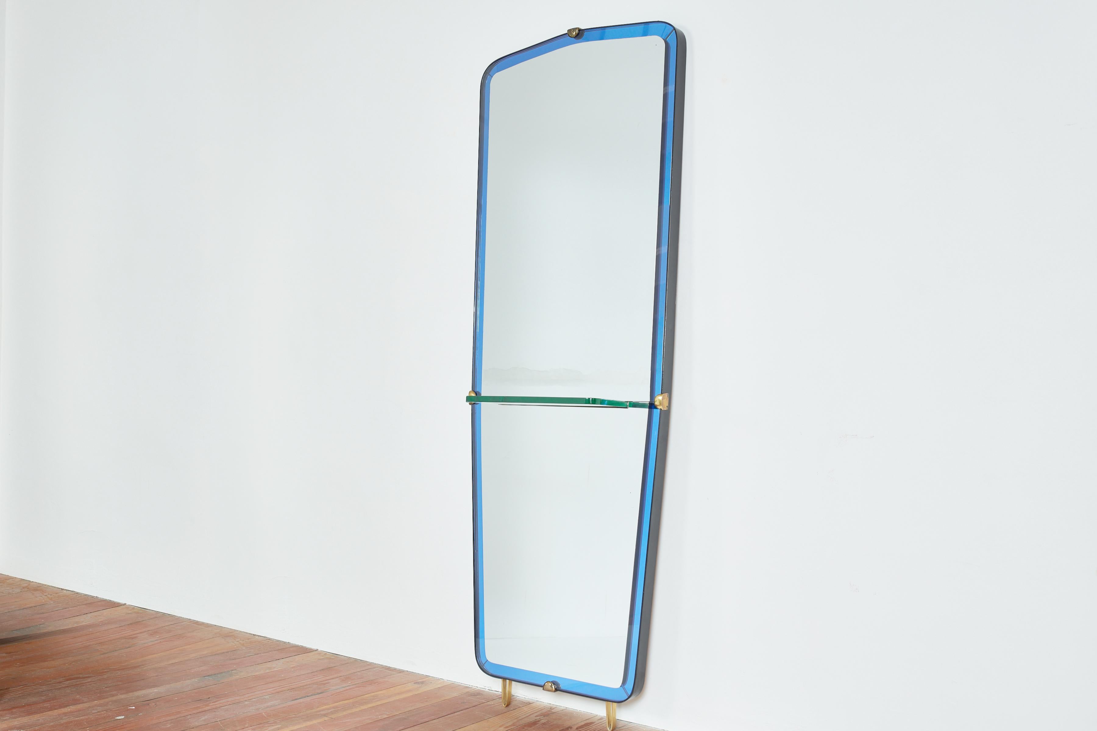 Gorgeous large Cristal Art wall mirror with bright blue cristal glass and thick glass shelf. 
Beautiful shape with brass accents and brass hairpin legs. 

Italy 1960s