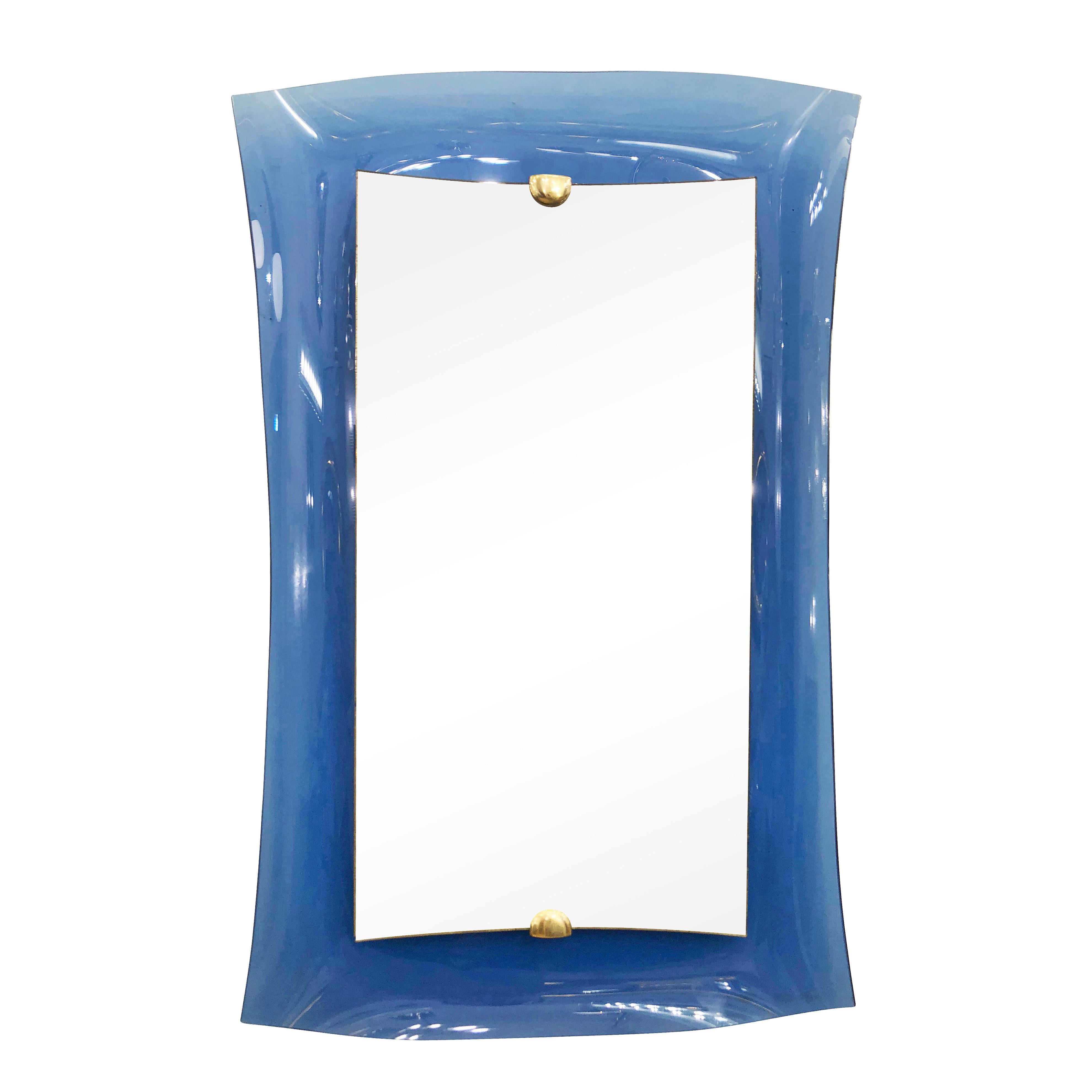 Midcentury mirror model 2712 by crystal Art. Features a concave blue glass frame with a raised glass center held by brass hardware.

Condition: Excellent vintage condition, minor wear consistent with age and use. Age spots to the edges of the