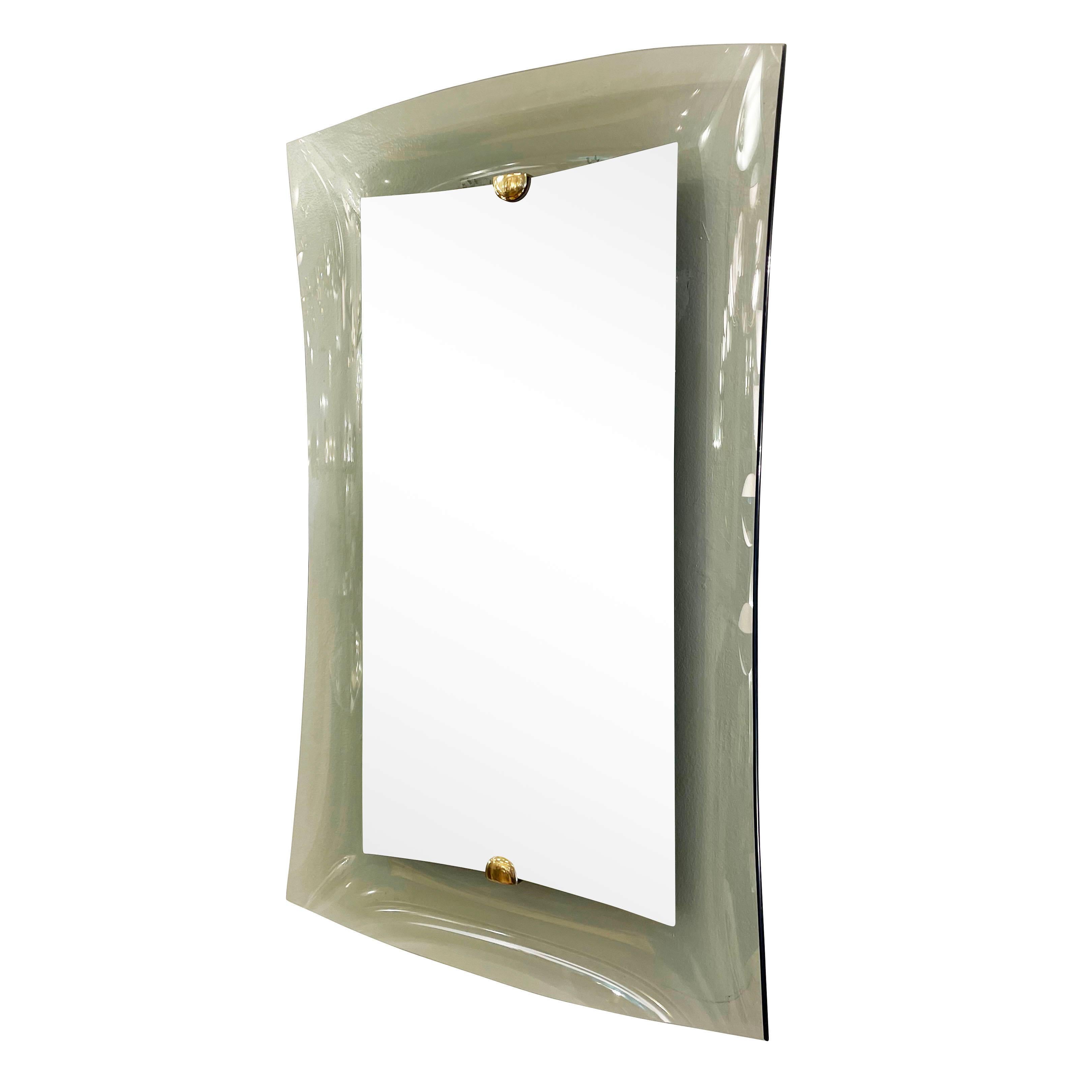 Mid-century mirror model 2712 by Cristal Arte. Features a concave gray smoked glass frame with a raised mirrored center held by brass hardware. 

Condition: Excellent vintage condition, minor wear consistent with age and use. Age spots to the