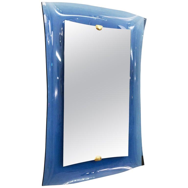 Spiegel aus der Mitte des Jahrhunderts, Modell 2712 von Cristal Arte. Sie hat einen konkaven blauen Glasrahmen mit einer erhöhten Glasmitte, die von Messingbeschlägen gehalten wird.

Zustand: Ausgezeichneter Vintage-Zustand, leichte
