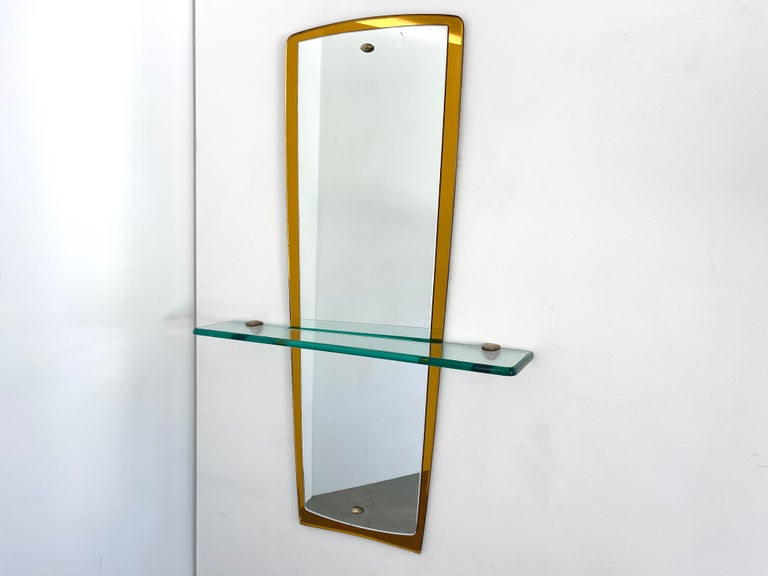 Gorgeous Cristal Arte mirror in mustard gold with floating shelf and brass hardware.