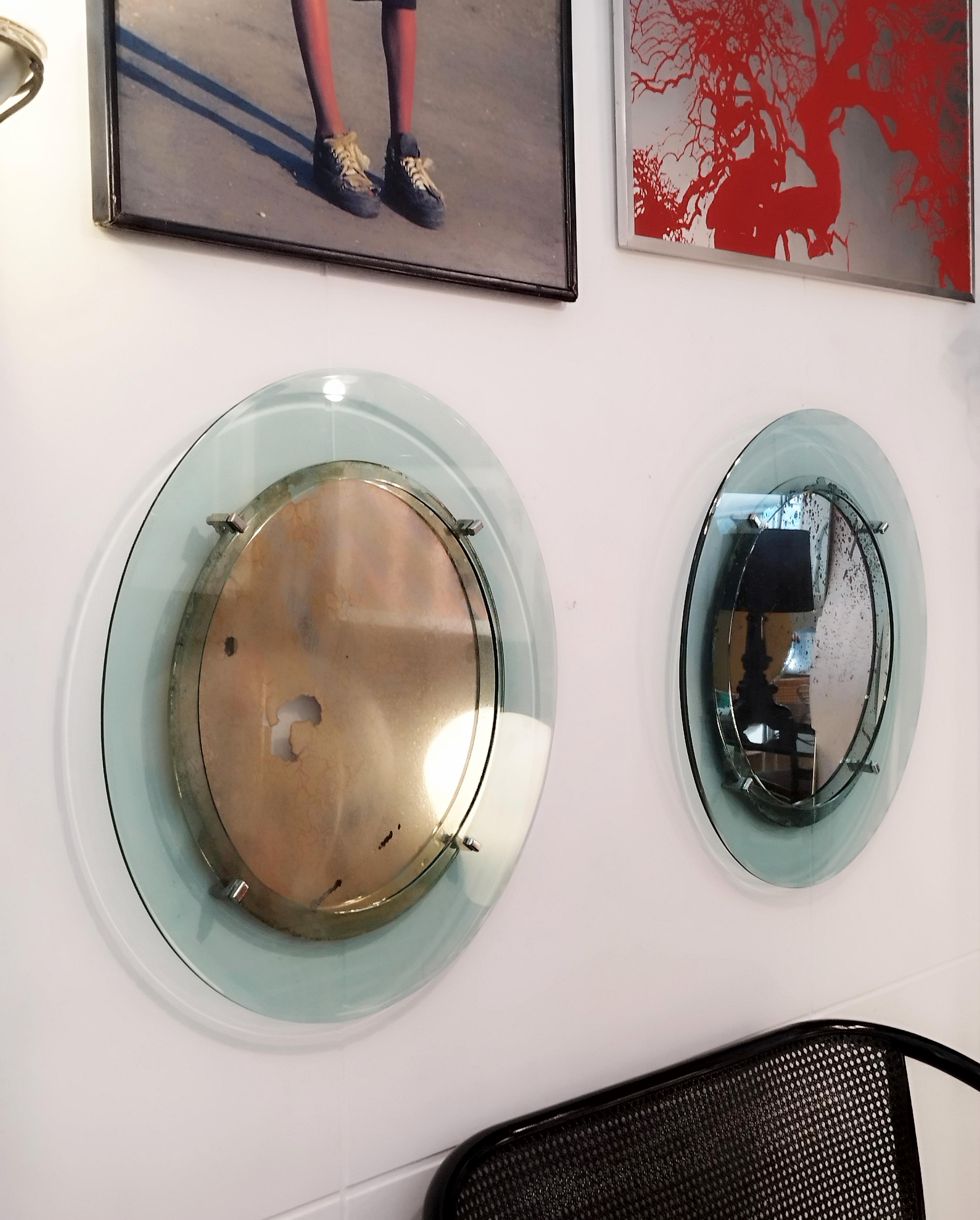 Rara coppia di specchi con cornice in cristallo color acquamarina e bordo intero smussato con placche in ottone nichelato, Italia anni '60 Gli specchi sono antichi coevi e quindi presentano difetti che non permettono una buona riflessione