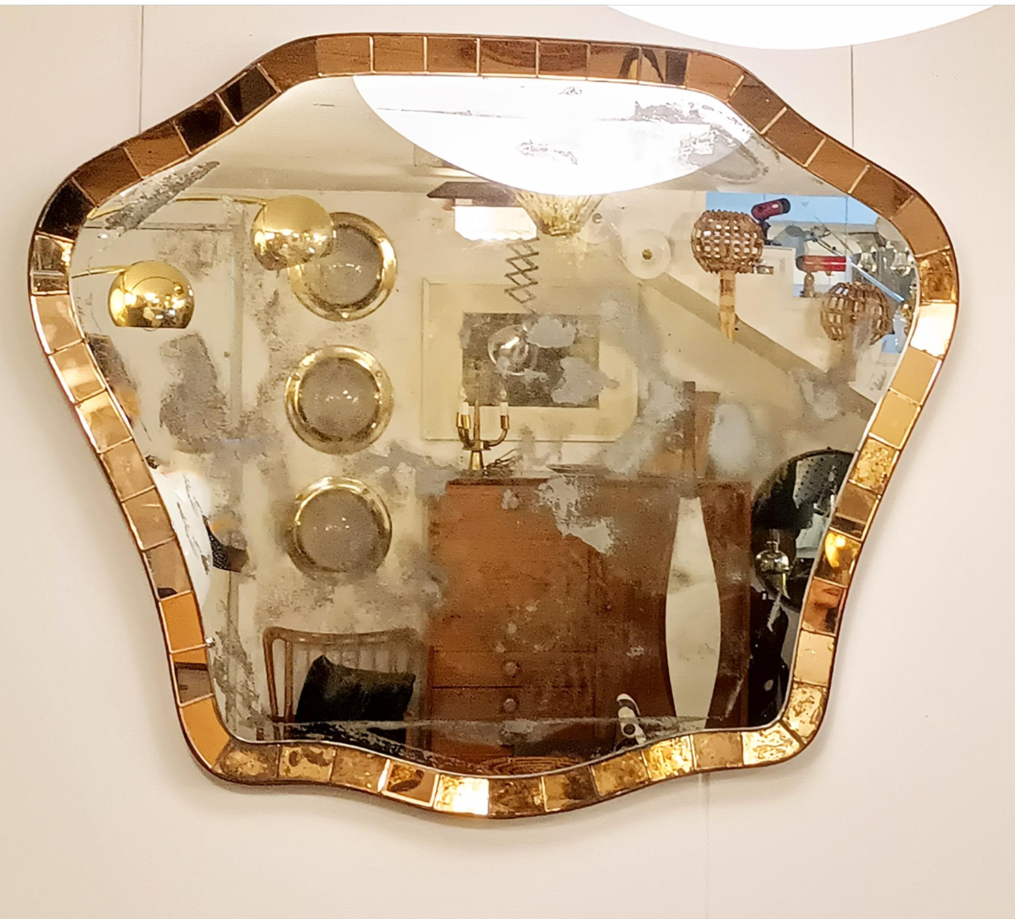 Magnifico e grandissimo specchio da parete, originale degli anni '50.
Realizzato dall'azienda italiana Cristal Art.
Elegante forma con una spessa cornice in cristallo molato color ambra. Anche il vetro dello specchio è originale degli anni 50 e